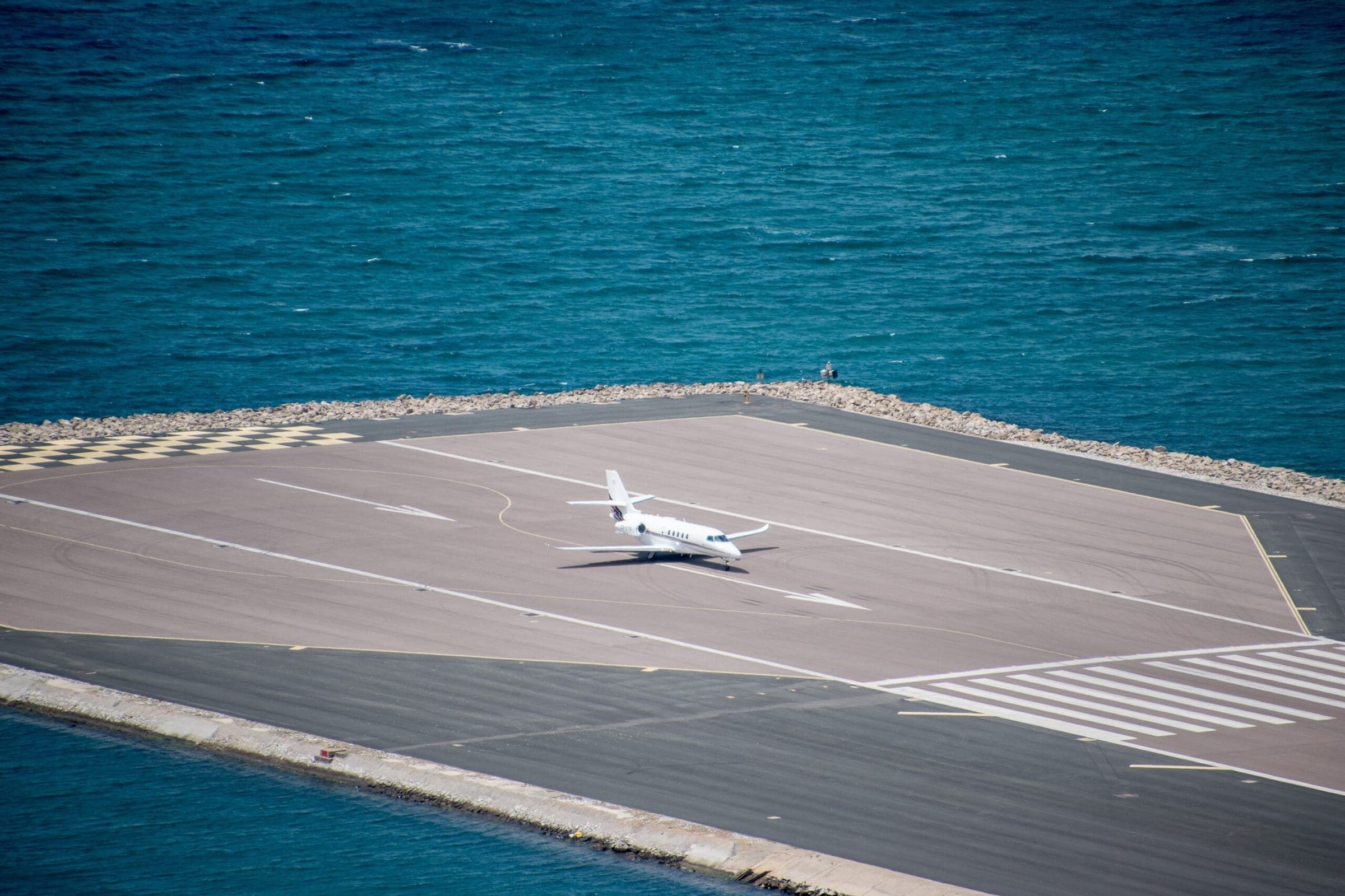 A private Cessna Citation business jet about to take of from the Gibraltar Airport, with the sea visible in the background