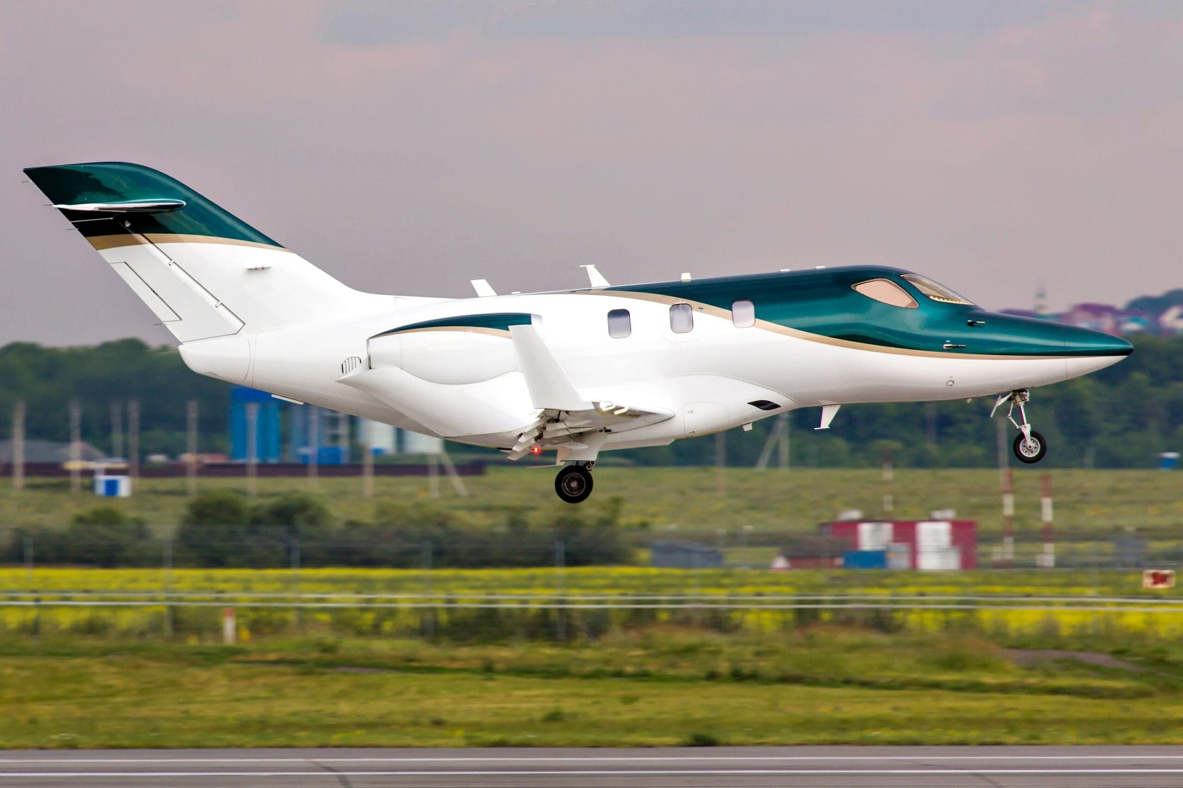 HondaJet with green and white paint coming in to land at airport