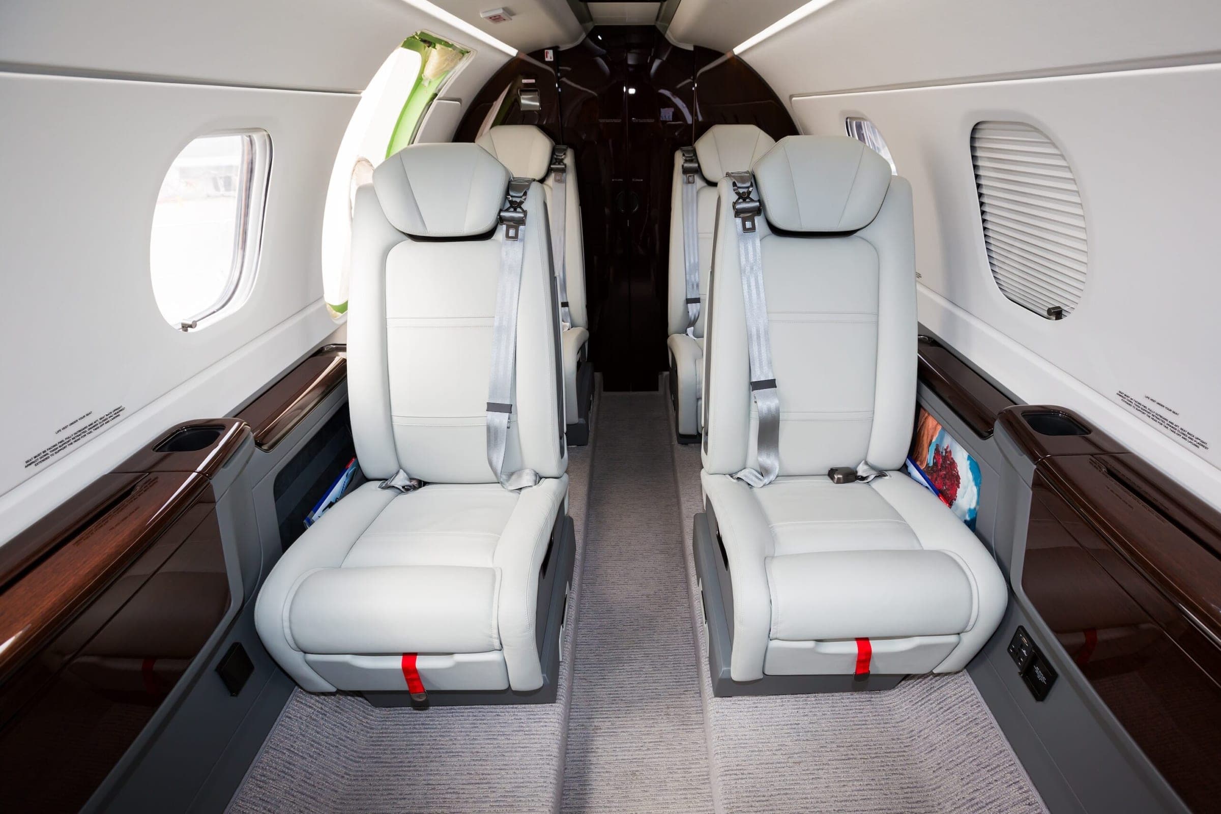 Light jet interior white leather seats from front of cabin looking back with window shades down