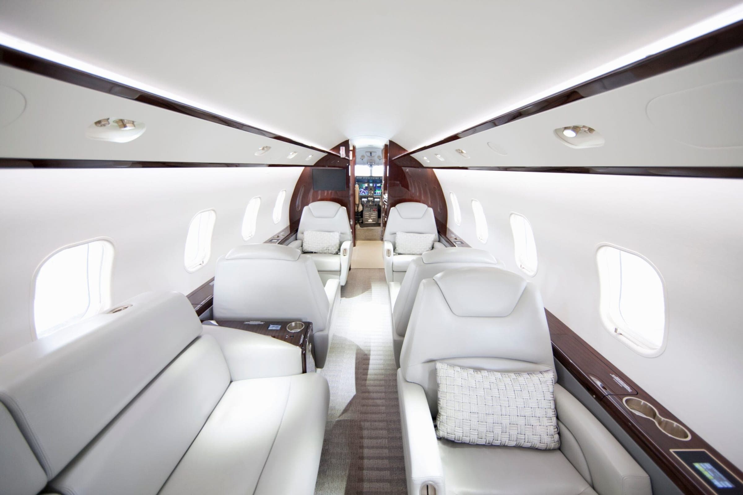 A wide shot showing interiors of a private jet from rear of cabin looking forward