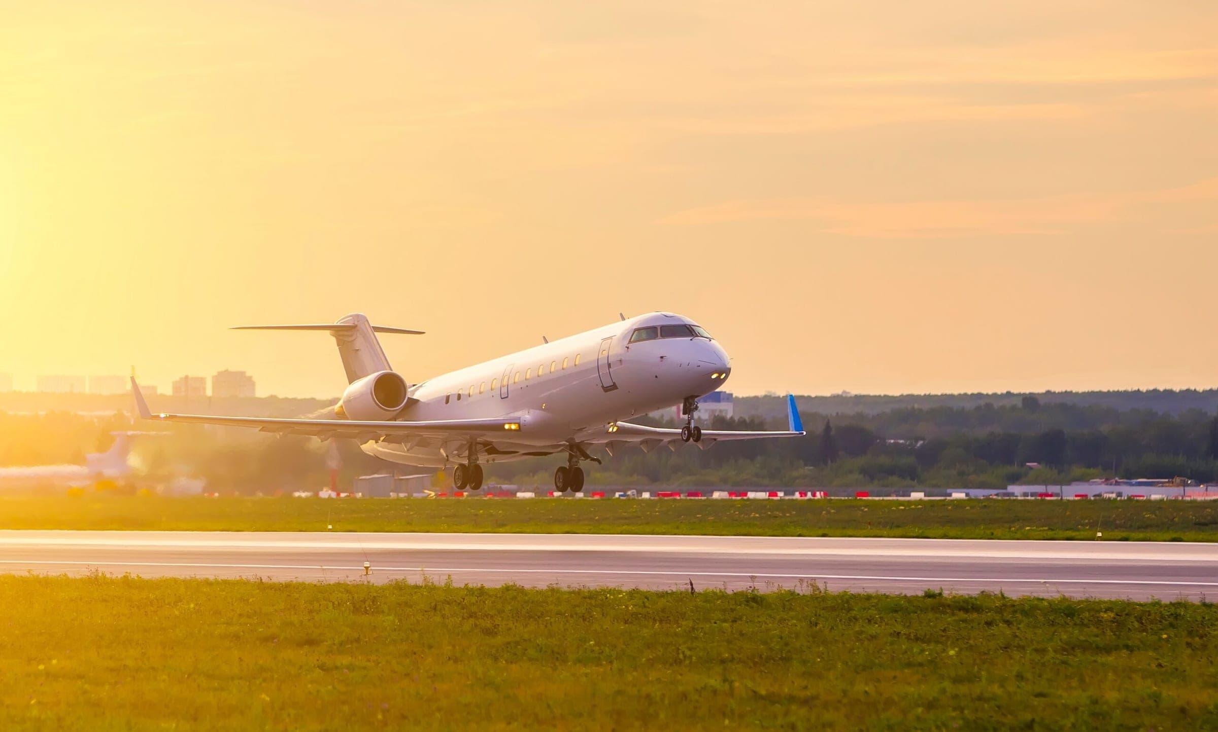 Bombardier private jet taking off against the background of sunset clouds and Golden light from sun