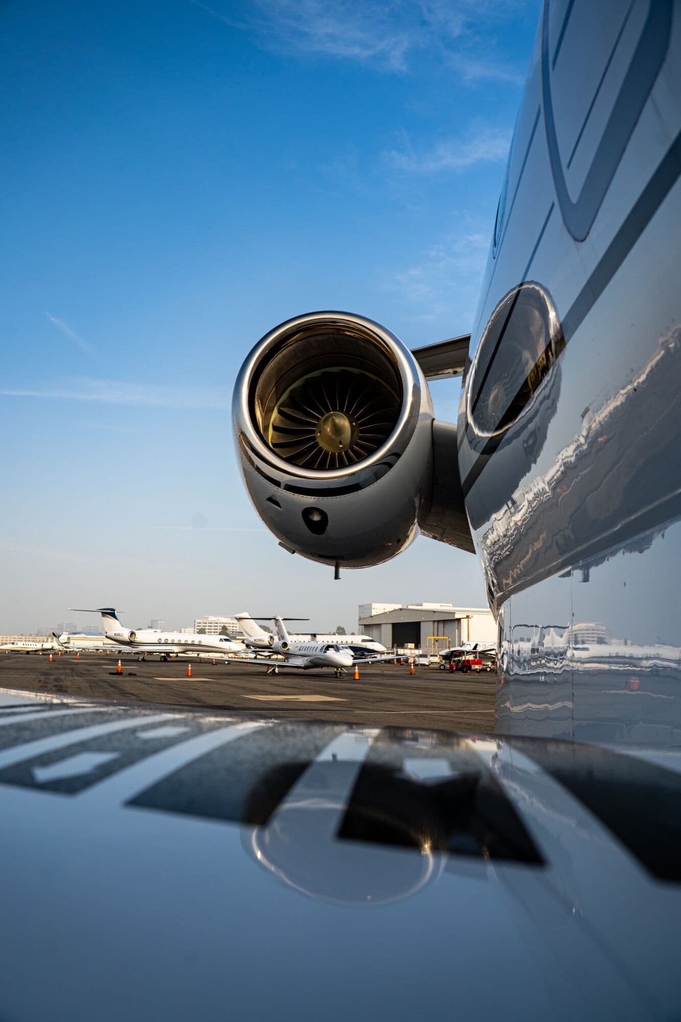 Close-up of a business jet engine on the ramp, other jets parked behind