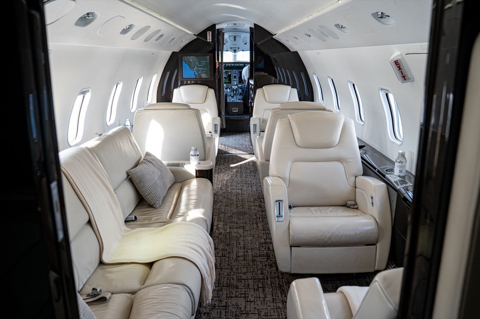 The cabin of a CRAFT Challenger 300, with club seats and a divan
