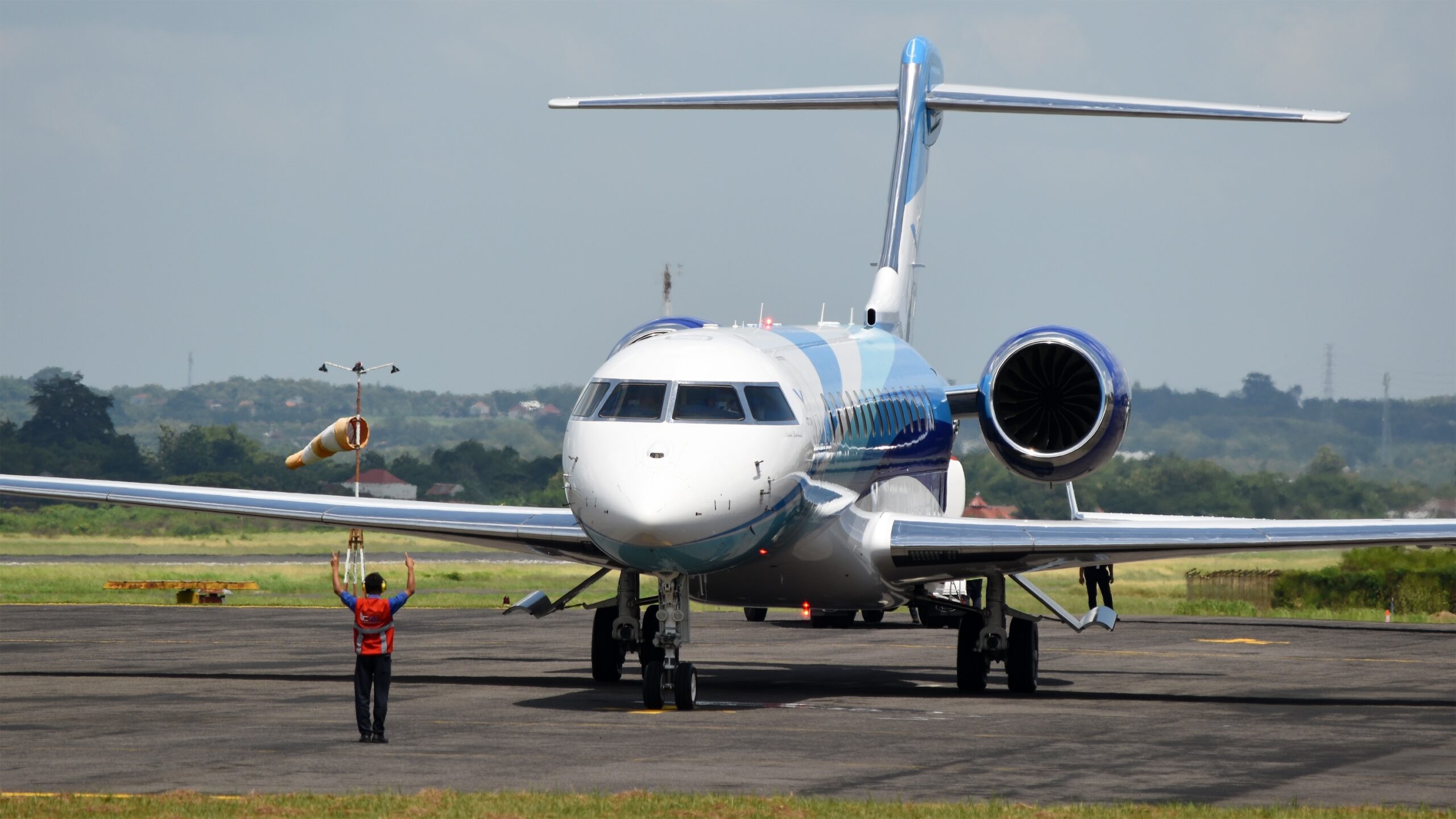 Bombardier Global 7500 on ground ready to start engine with marshaler in front