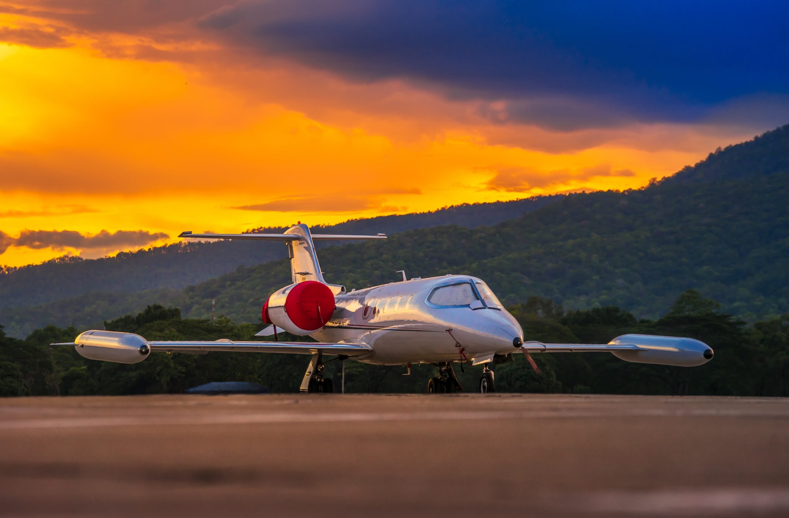 Airplane model of Bombardier Learjet 35A parking on the apron with beautiful sunset and mountain Background.