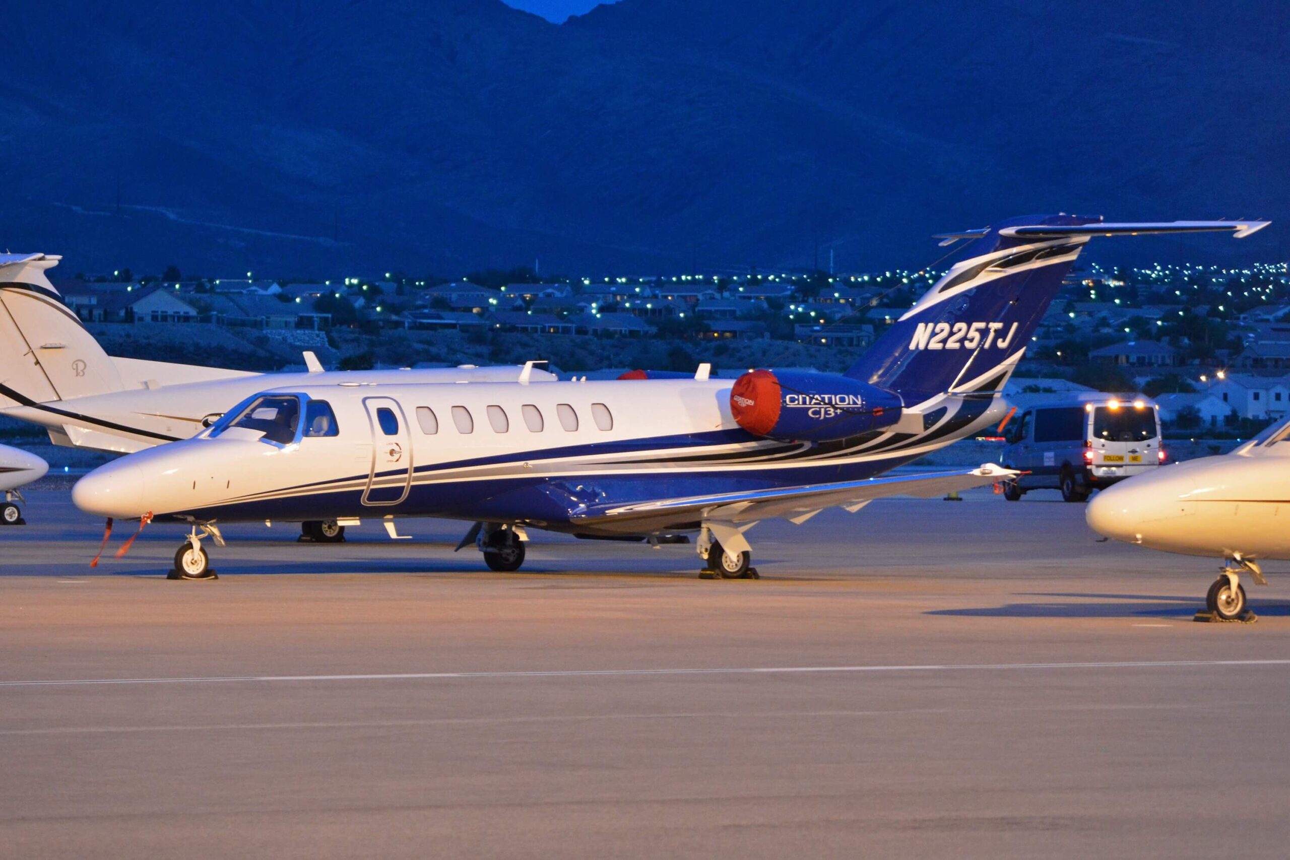 Cessna Citation CJ3+ on ramp with blue tail at night, reg number N225TJ