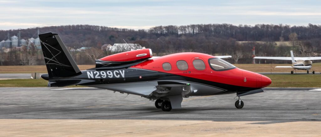 Exterior of Cirrus Vision Jet SF50 on ground right hand side, red and black, reg number N299CV