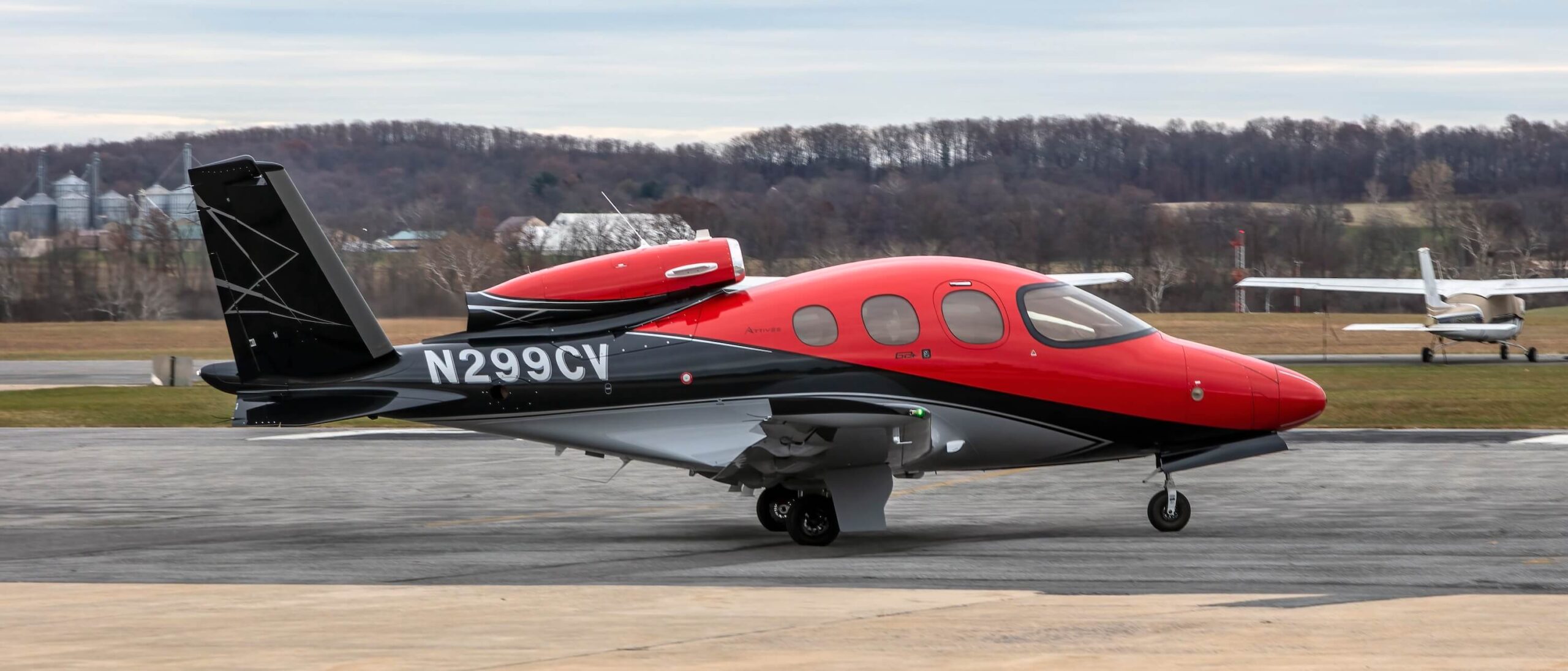 Exterior of Cirrus Vision Jet SF50 on ground right hand side, red and black, reg number N299CV