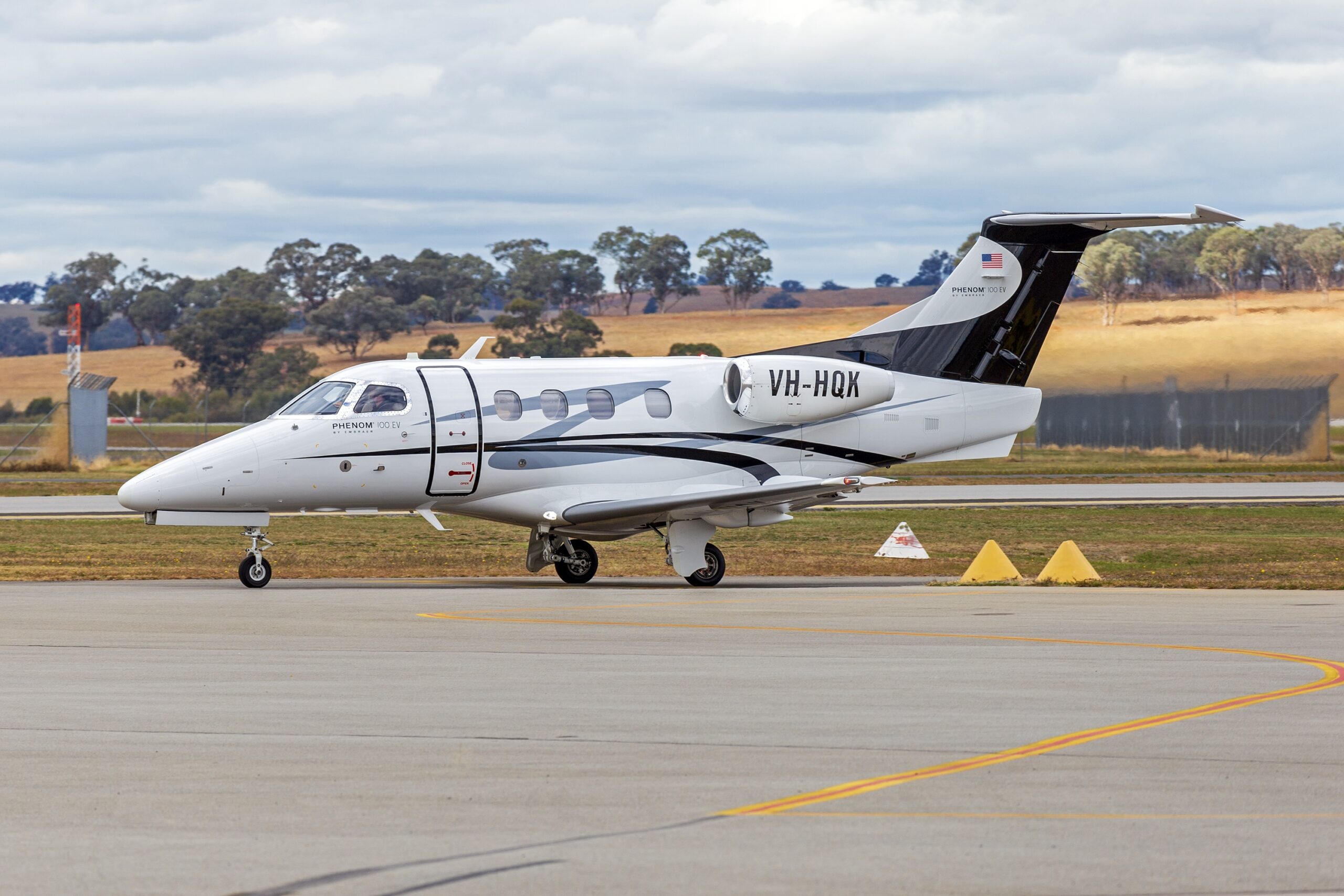 Embraer Phenom 100EV reg number VH-HQK on ground at airport