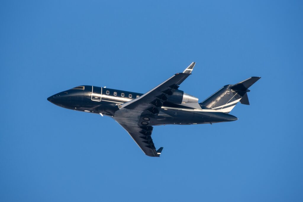 Black Bombardier Challenger 605 taking off from airport