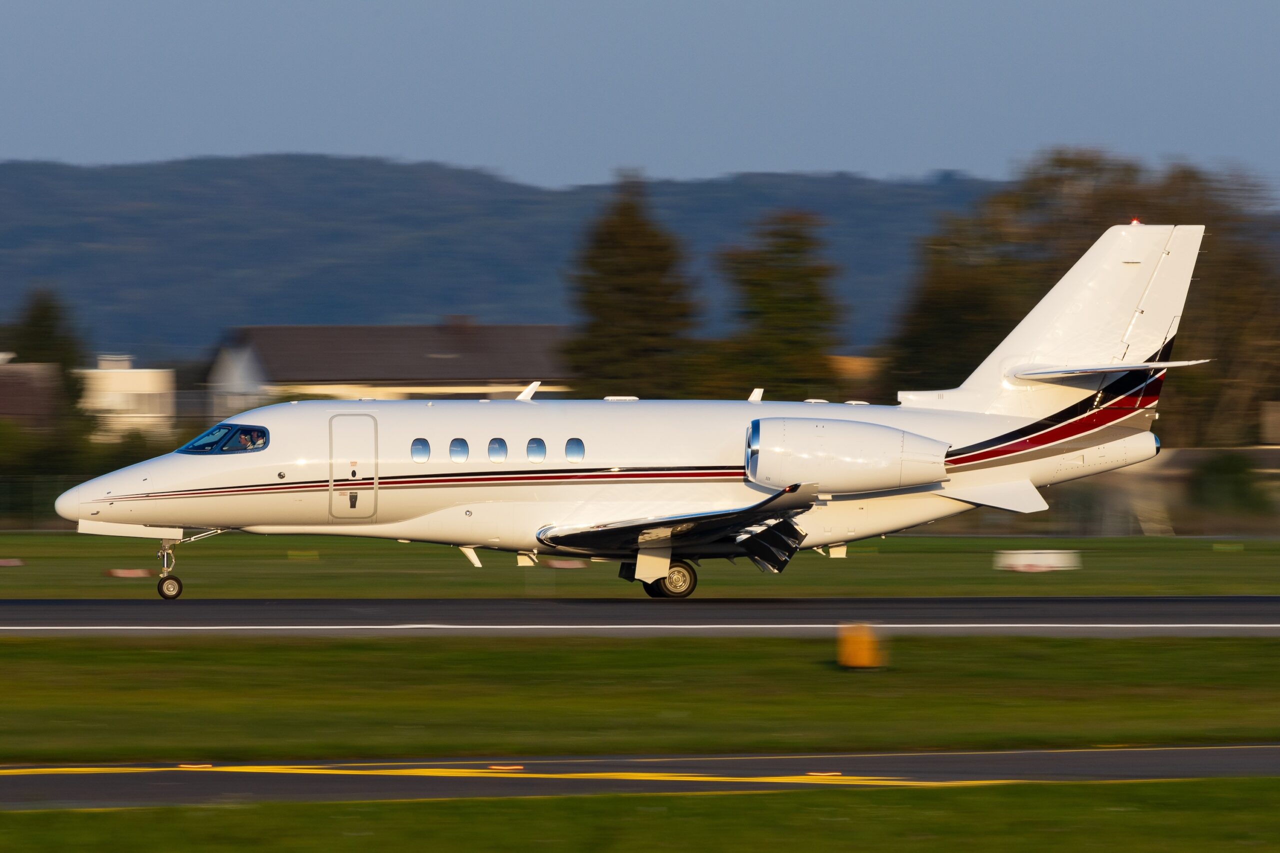 Cessna Citation midsize jet in motion landing on runway with blurred background