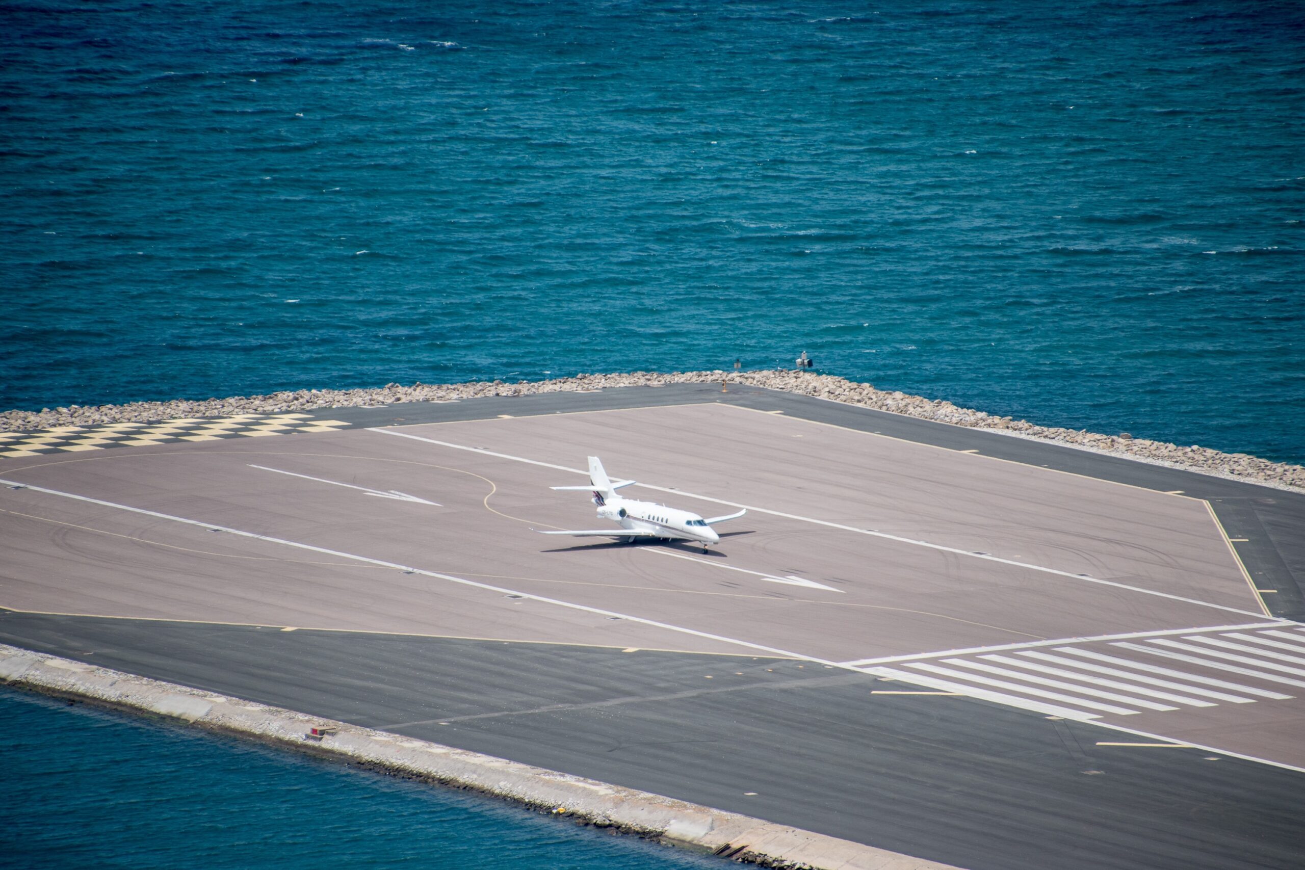 A private Cessna Citation business jet about to take of from the Gibraltar Airport, with the sea visible in the background