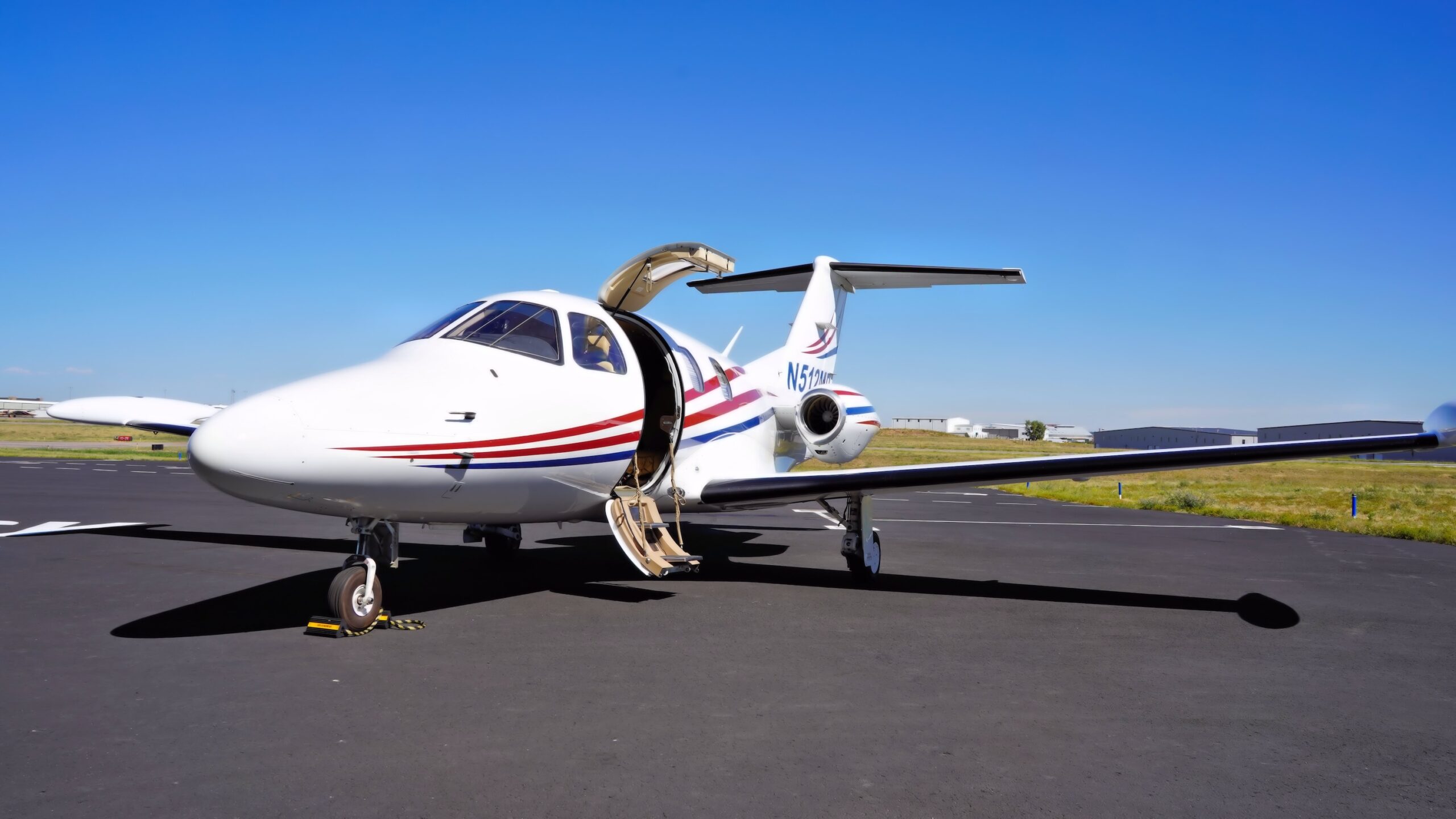 Eclipse 500 jet parked on apron at airport with the door open