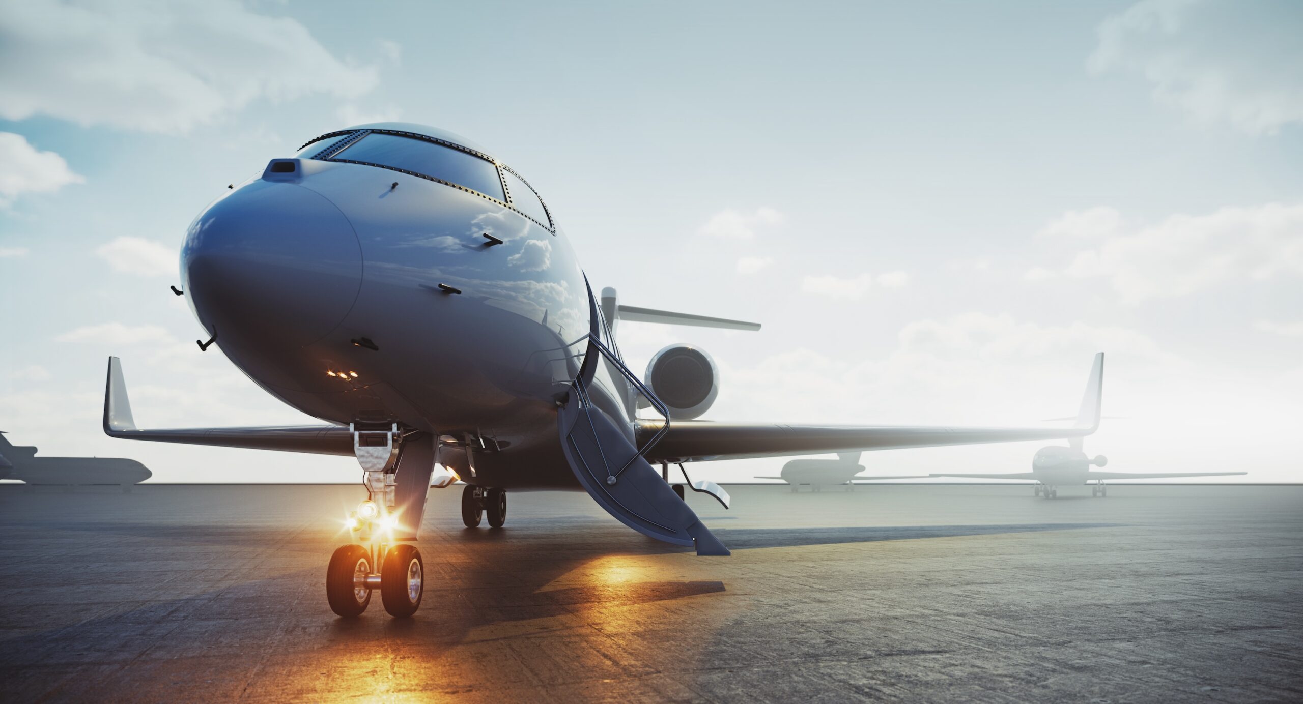 Private jet with stairs deployed and nose lights on front on view at airport during fog