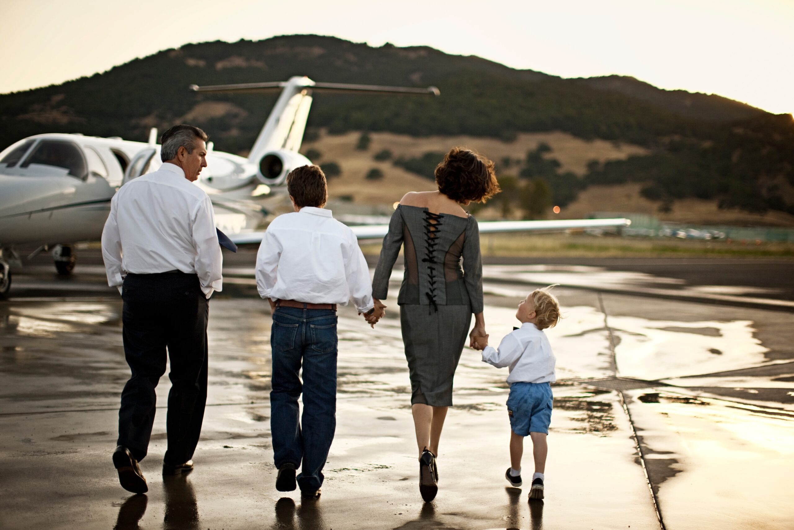 Family walking towards a Cessna Citation private jet holding hands
