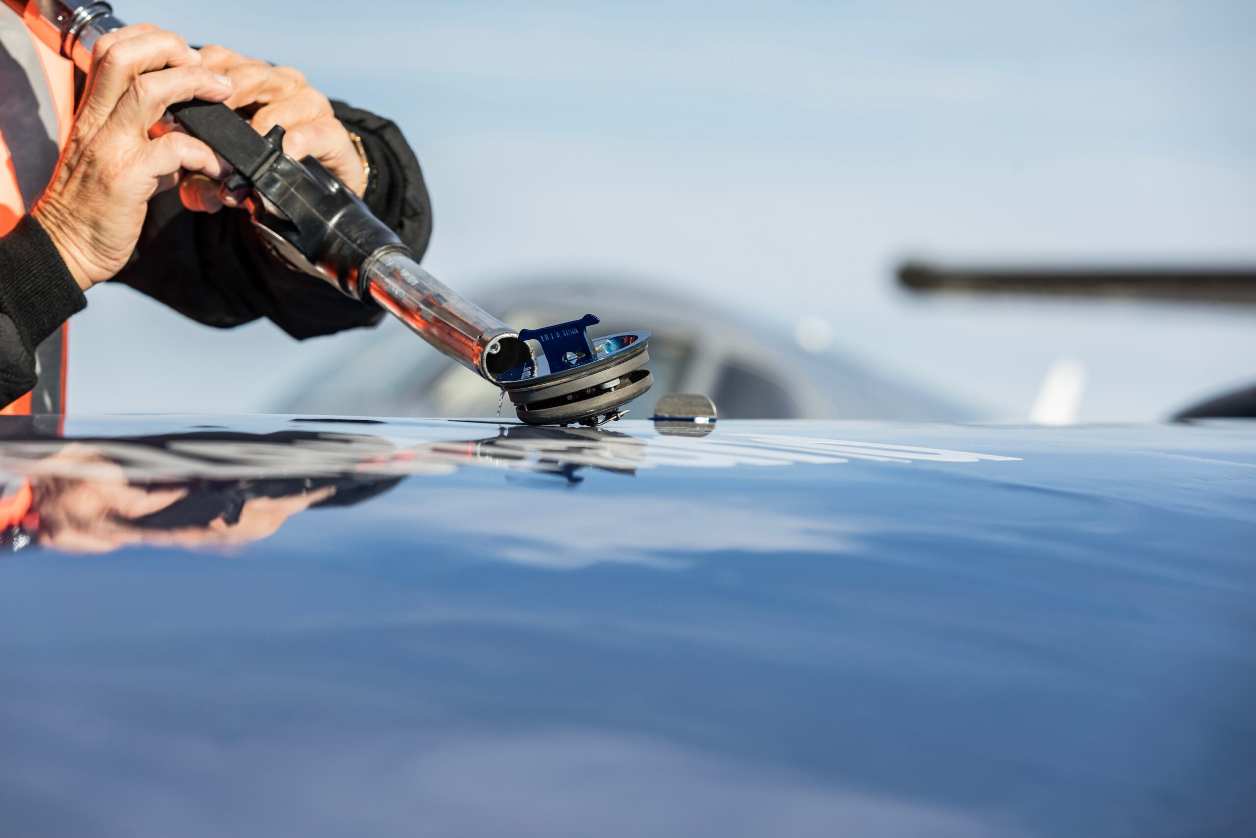 Refueling the plane. The FBO refuels the business aircraft before departure. Close-up of a hand with a tank gun.
