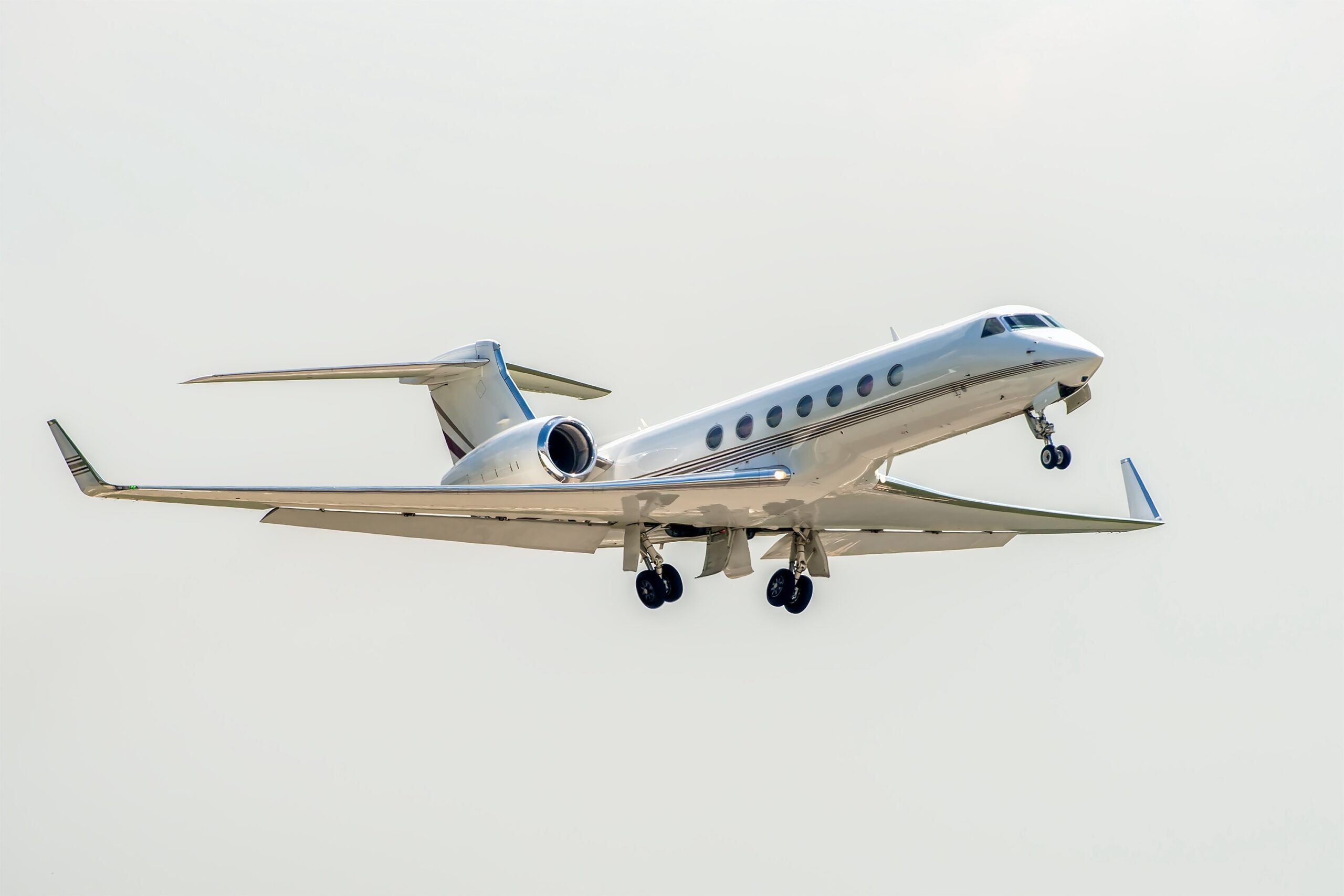 White Gulfstream in air with landing gear in motion
