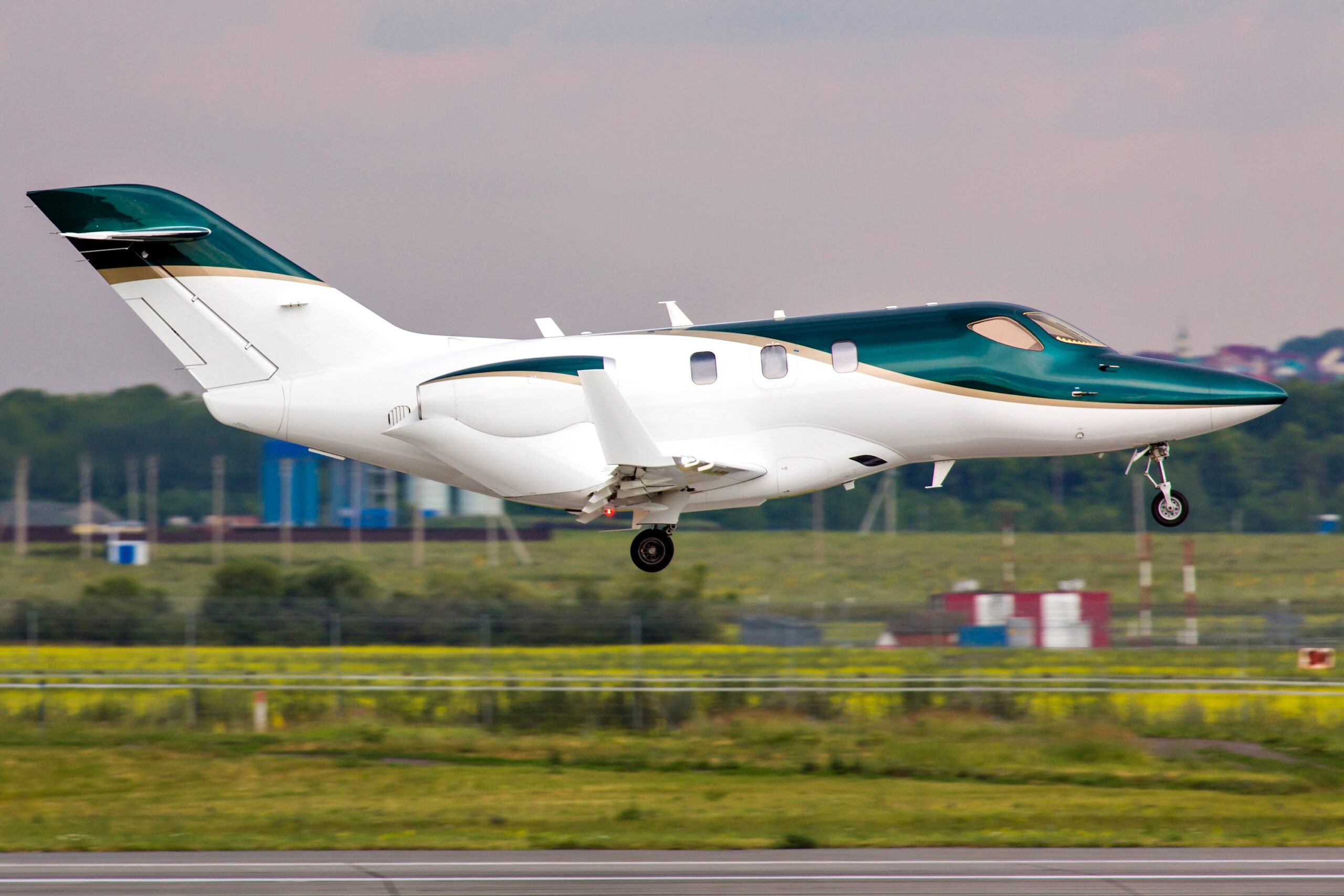 HondaJet with green and white paint coming in to land at airport