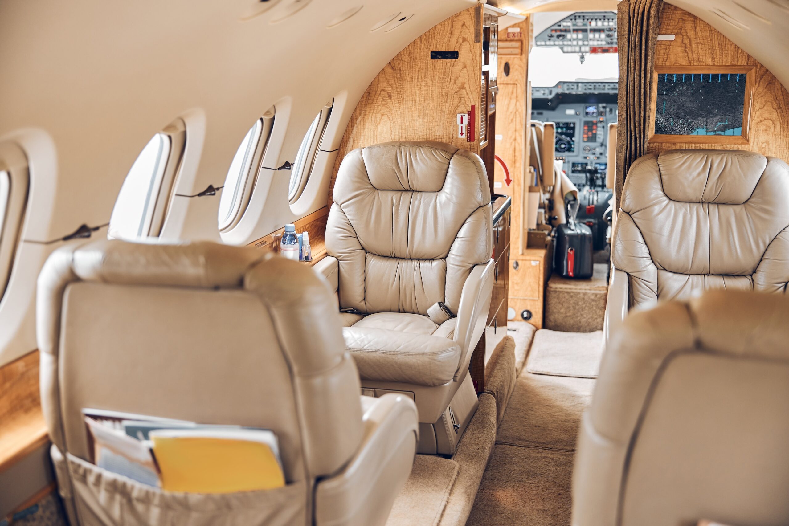 Interior private jet from rear of cabin looking forward, focus on the front most seats