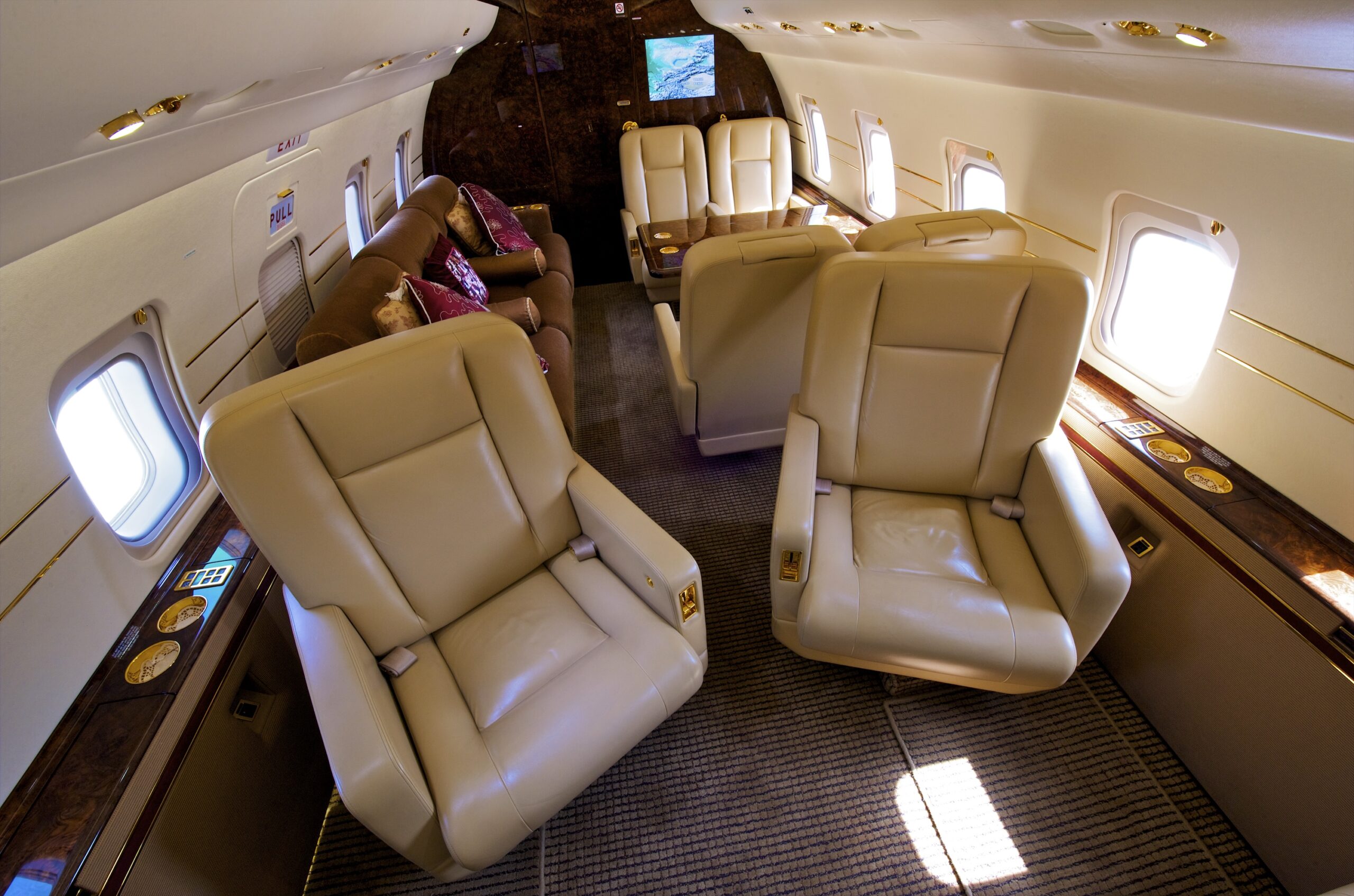 Interior of private jet with seats angled in to aisle