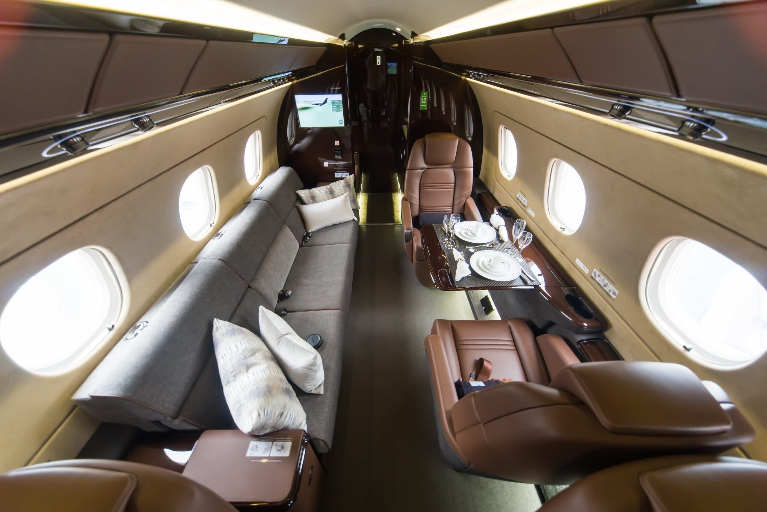 Embraer Legacy rear interior with table setup and divan