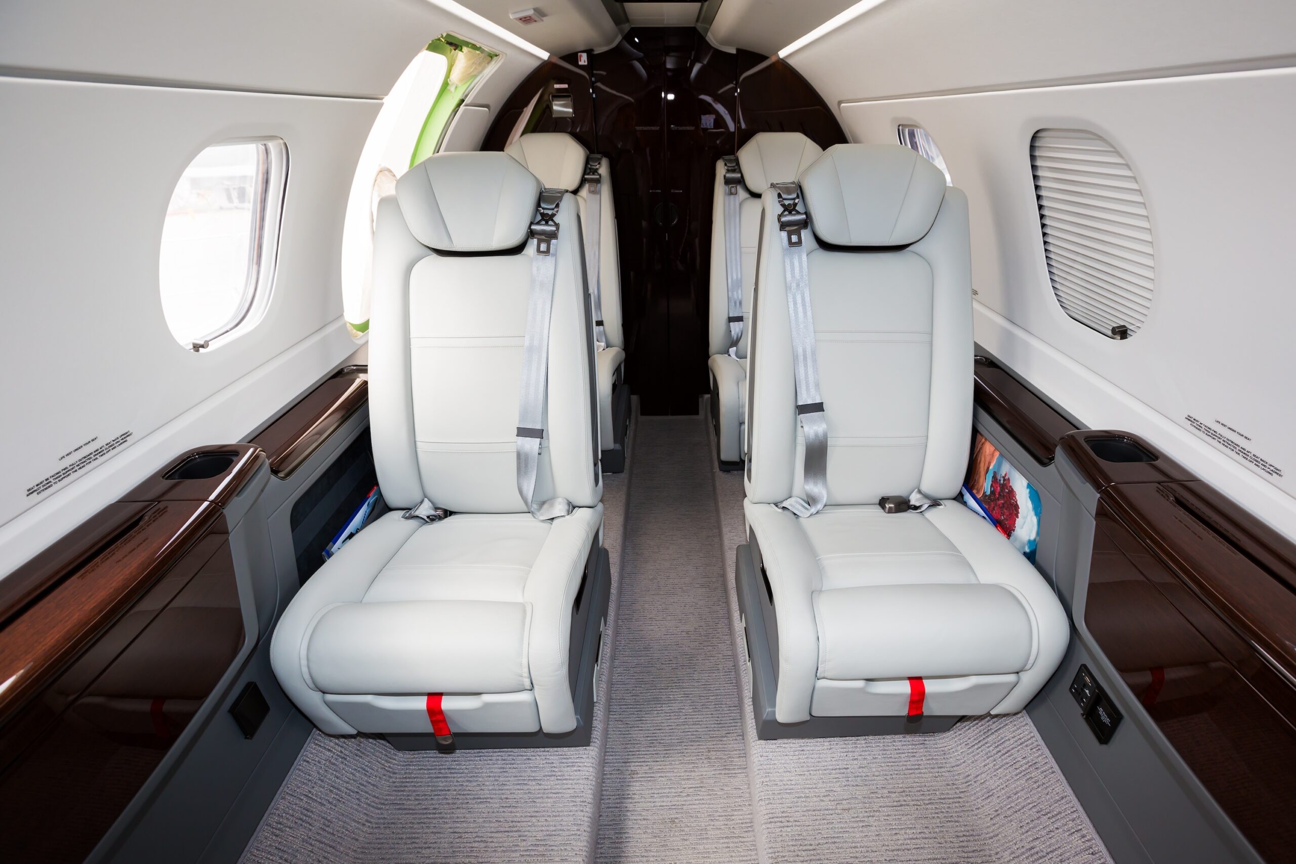Light jet interior white leather seats from front of cabin looking back with window shades down