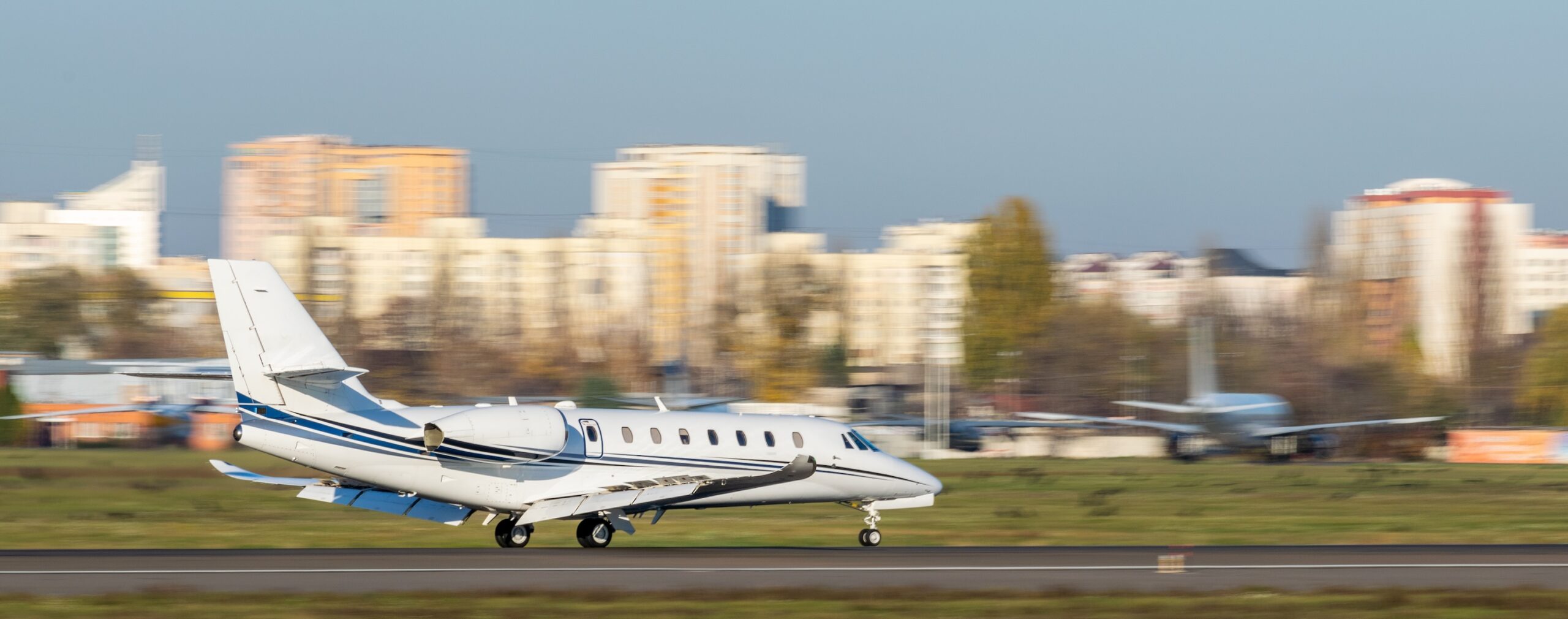Private Jet landing at airport with speed brakes deployed and blurred background