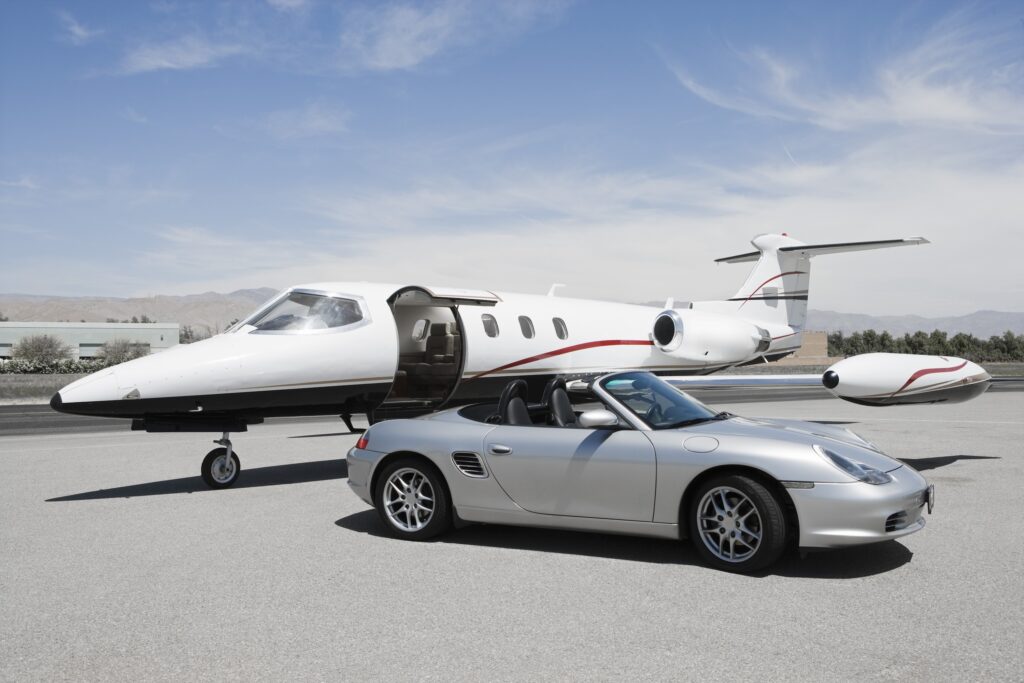 View of a Porsche Boxster and Learjet private jet at airport