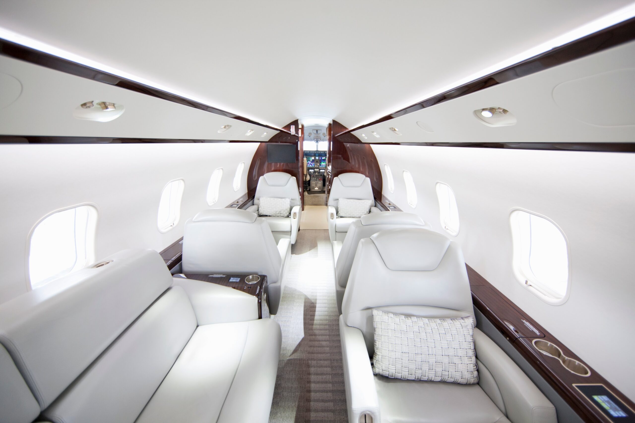 A wide shot showing interiors of a private jet from rear of cabin looking forward
