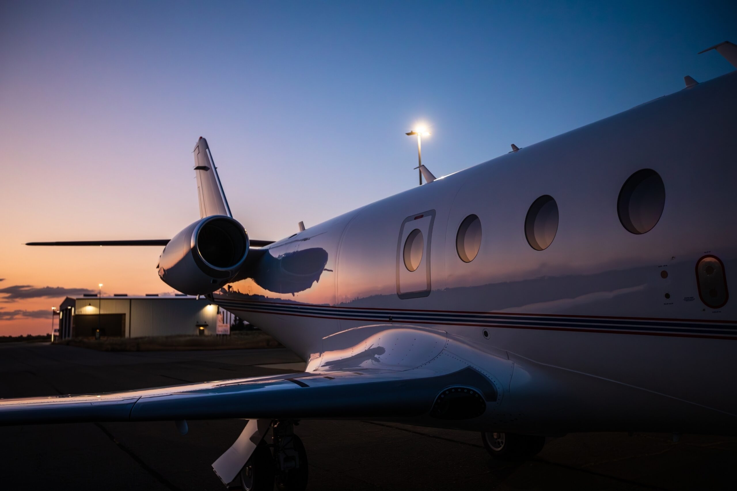 Private jet rear three quarters perparing for take off at sunset reflecting off the fuselage