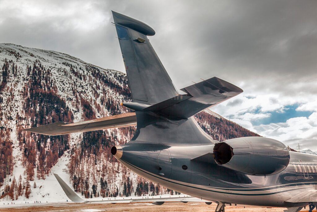 Tail view of private jet with mountains in the background
