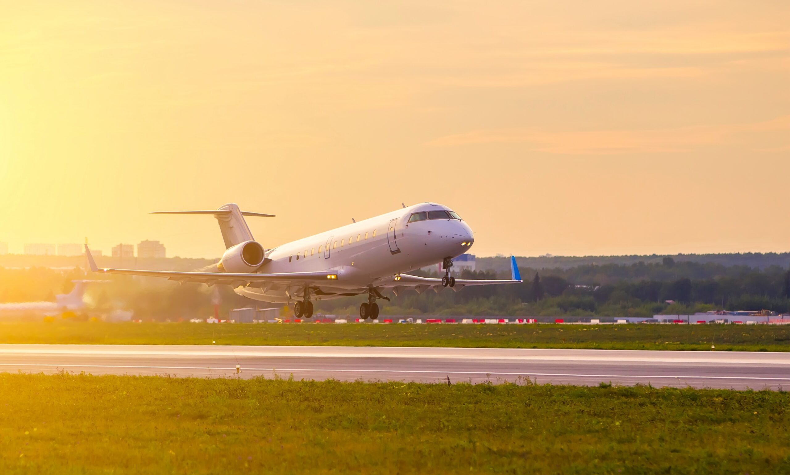 Bombardier private jet taking off against the background of sunset clouds and Golden light from sun