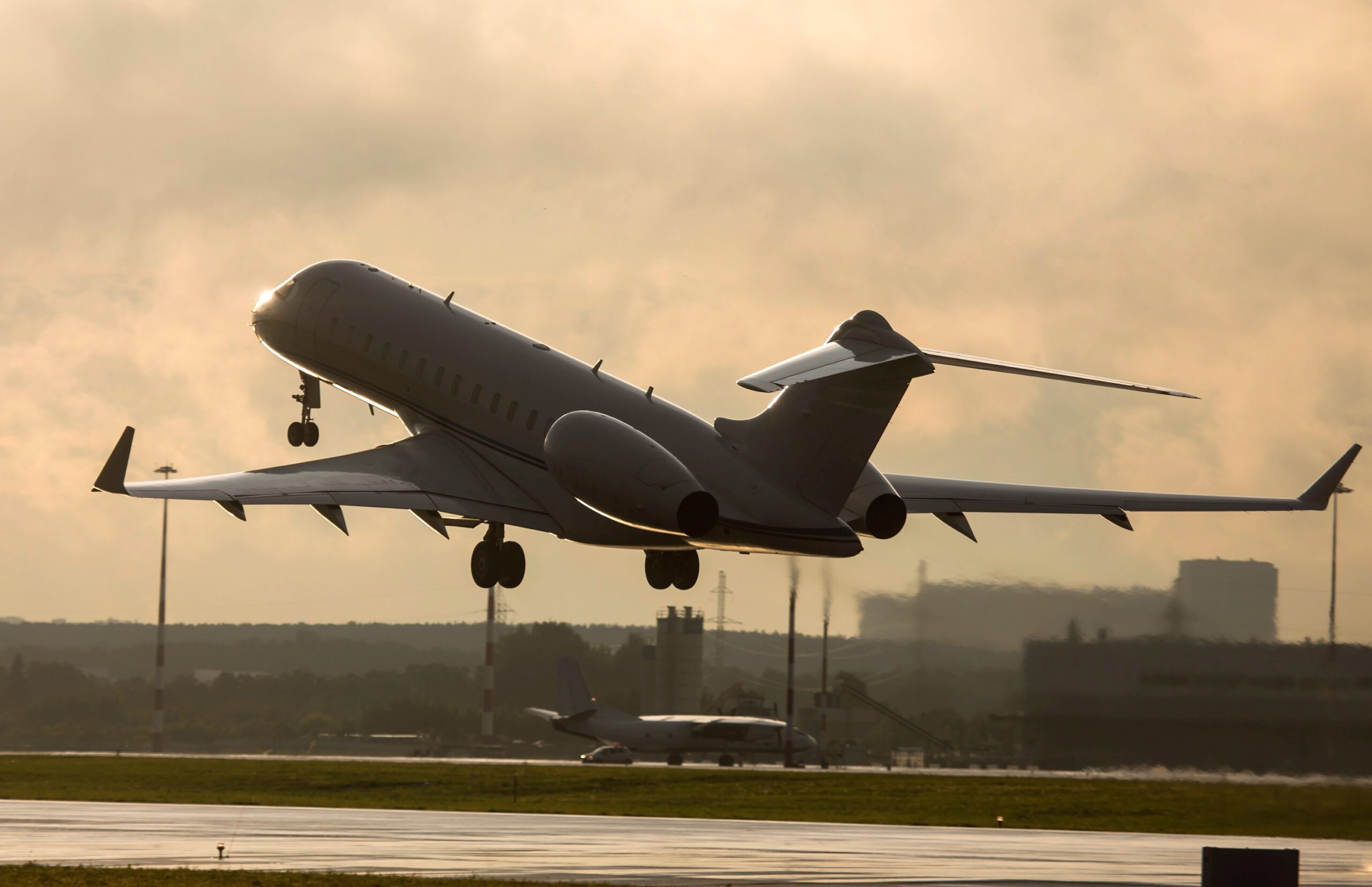 White Bombardier private jet taking off from airport at dawn