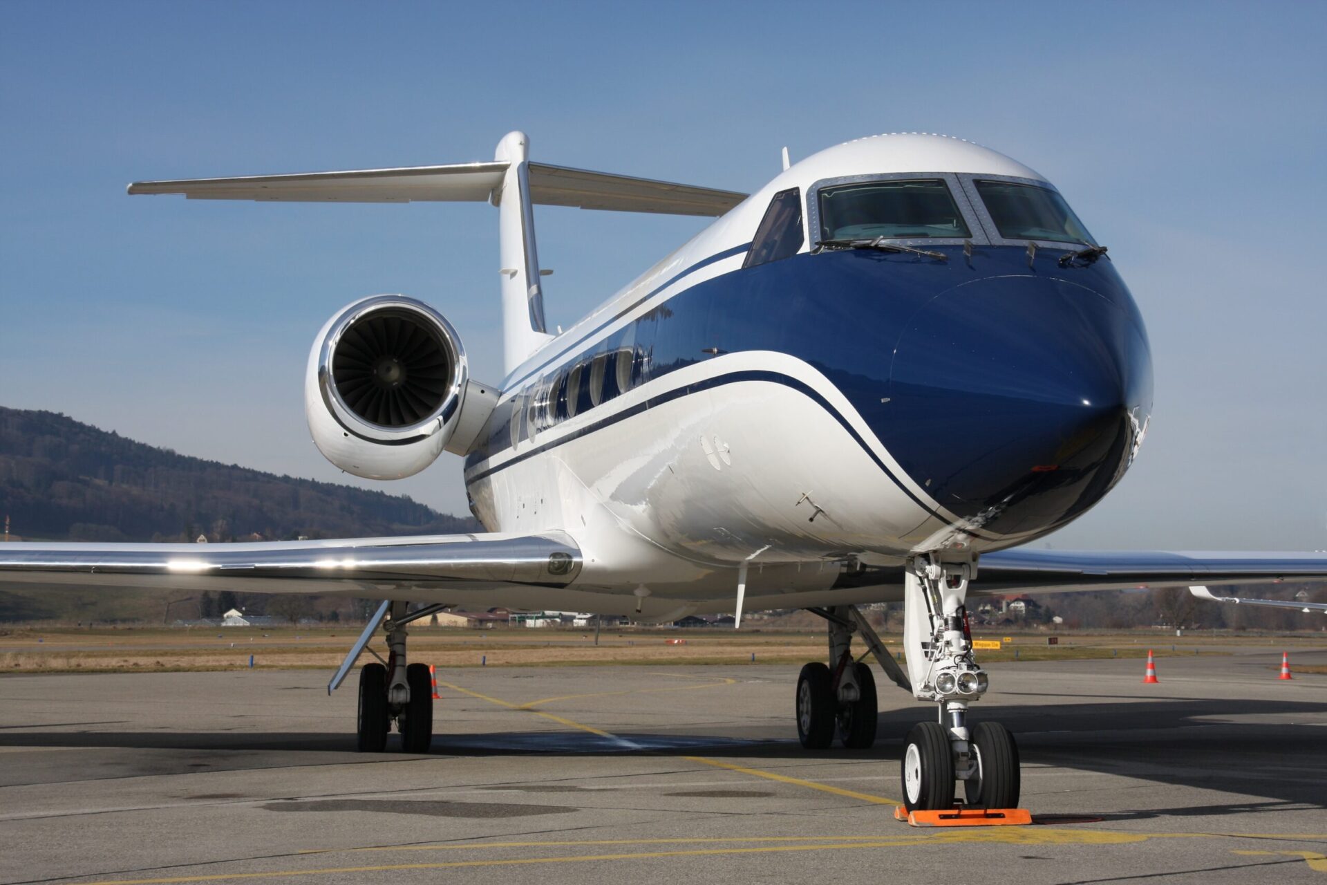 Gulfstream G550 sitting on the ramp, white and blue paint stripe