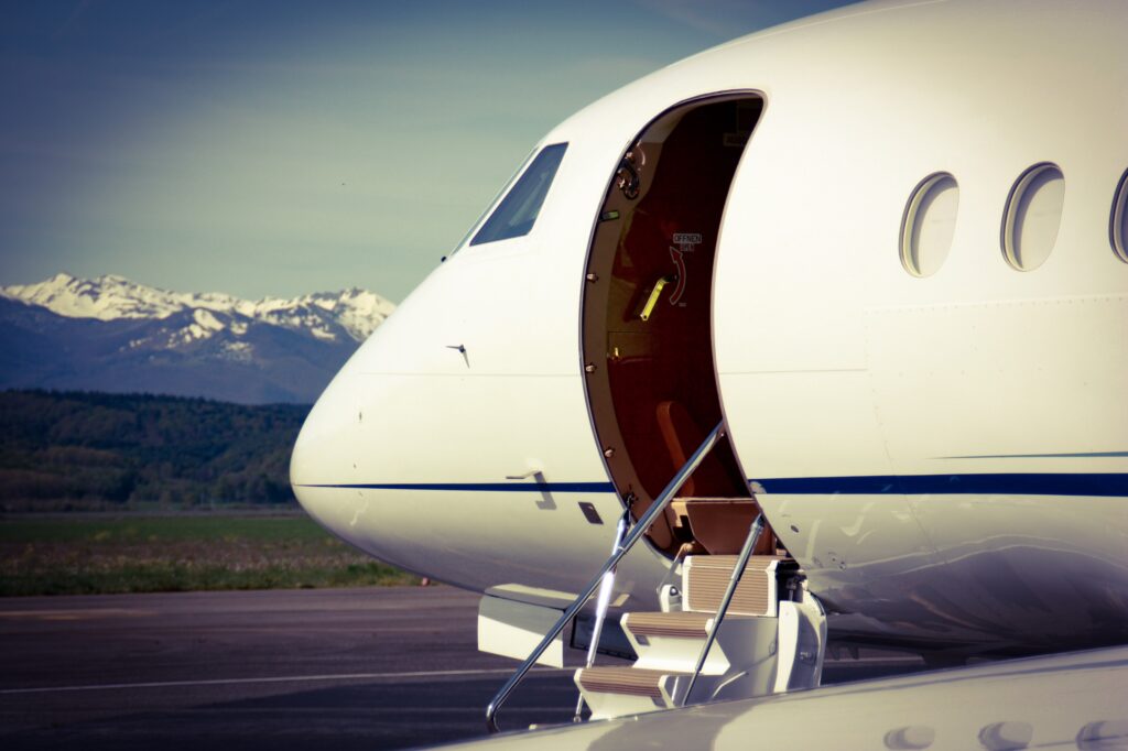 Business Jet with open door waiting for passengers with mountains in the background