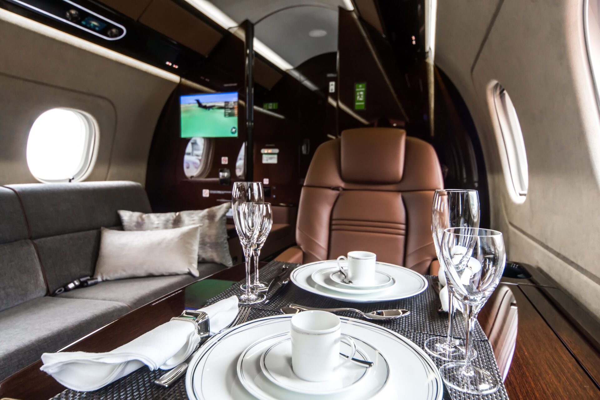 Embraer Legacy interior seat and divan with table laid for meal