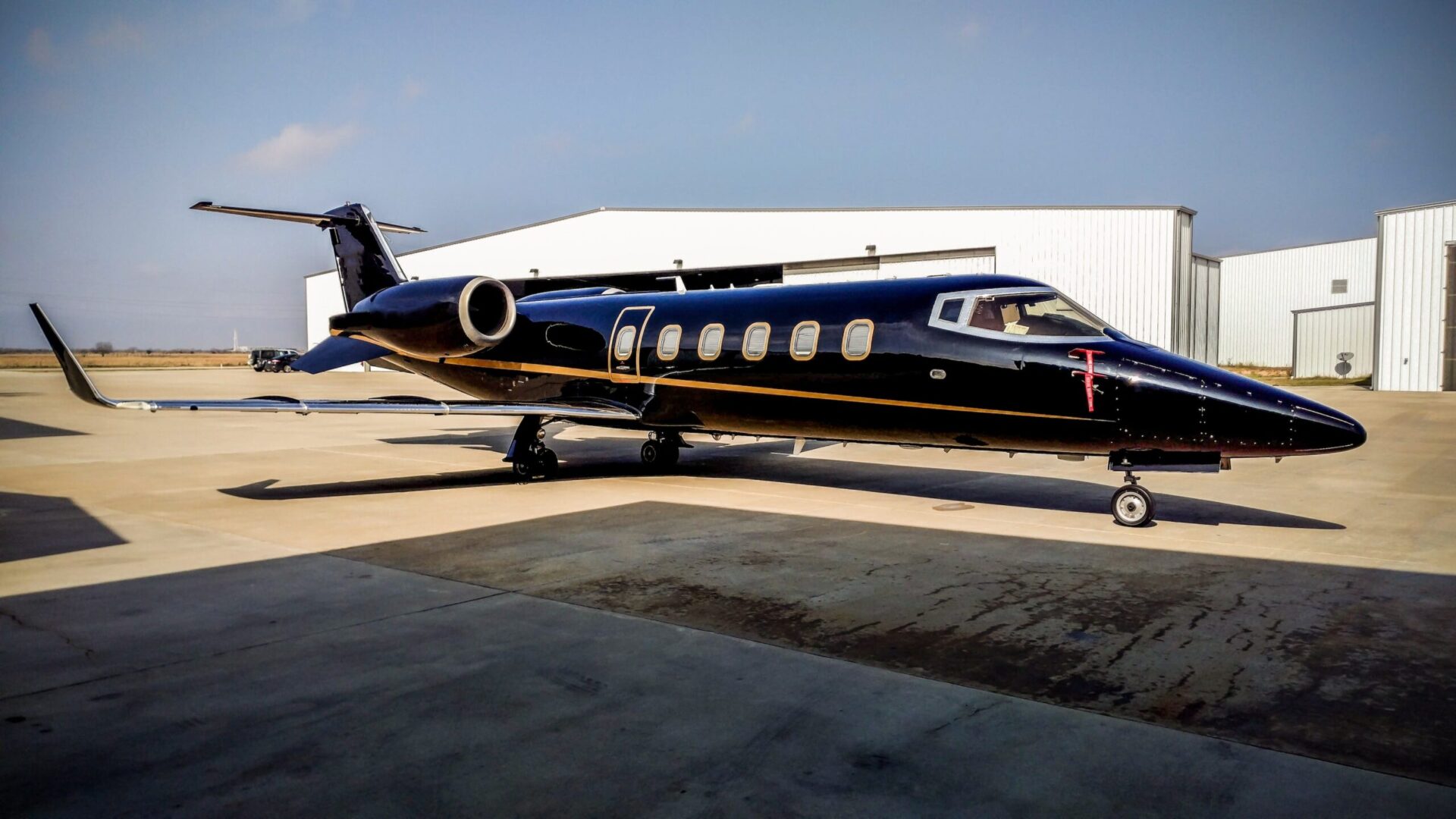 Black Learjet 60 parked at airport, waiting for empty leg