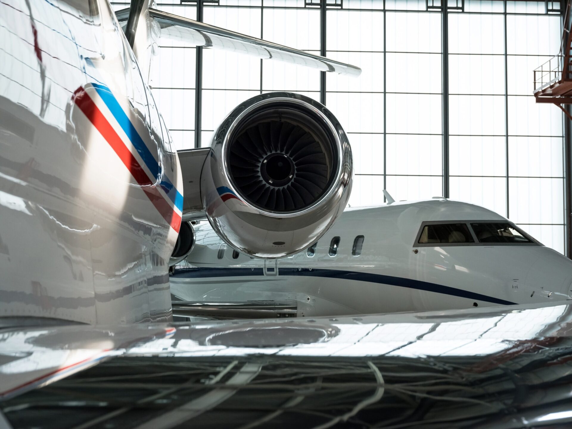 Rear engine view of private jet in hangar with Challenger in the bacjground