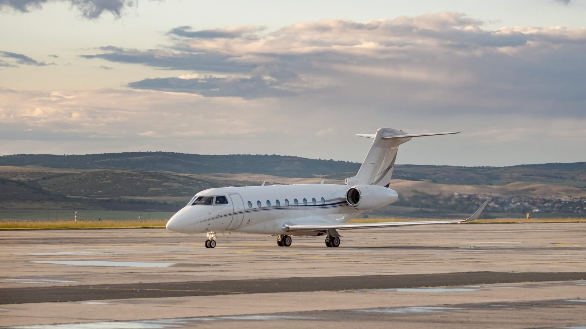 Gulfstream G280 white parked at airport with dramatic sky