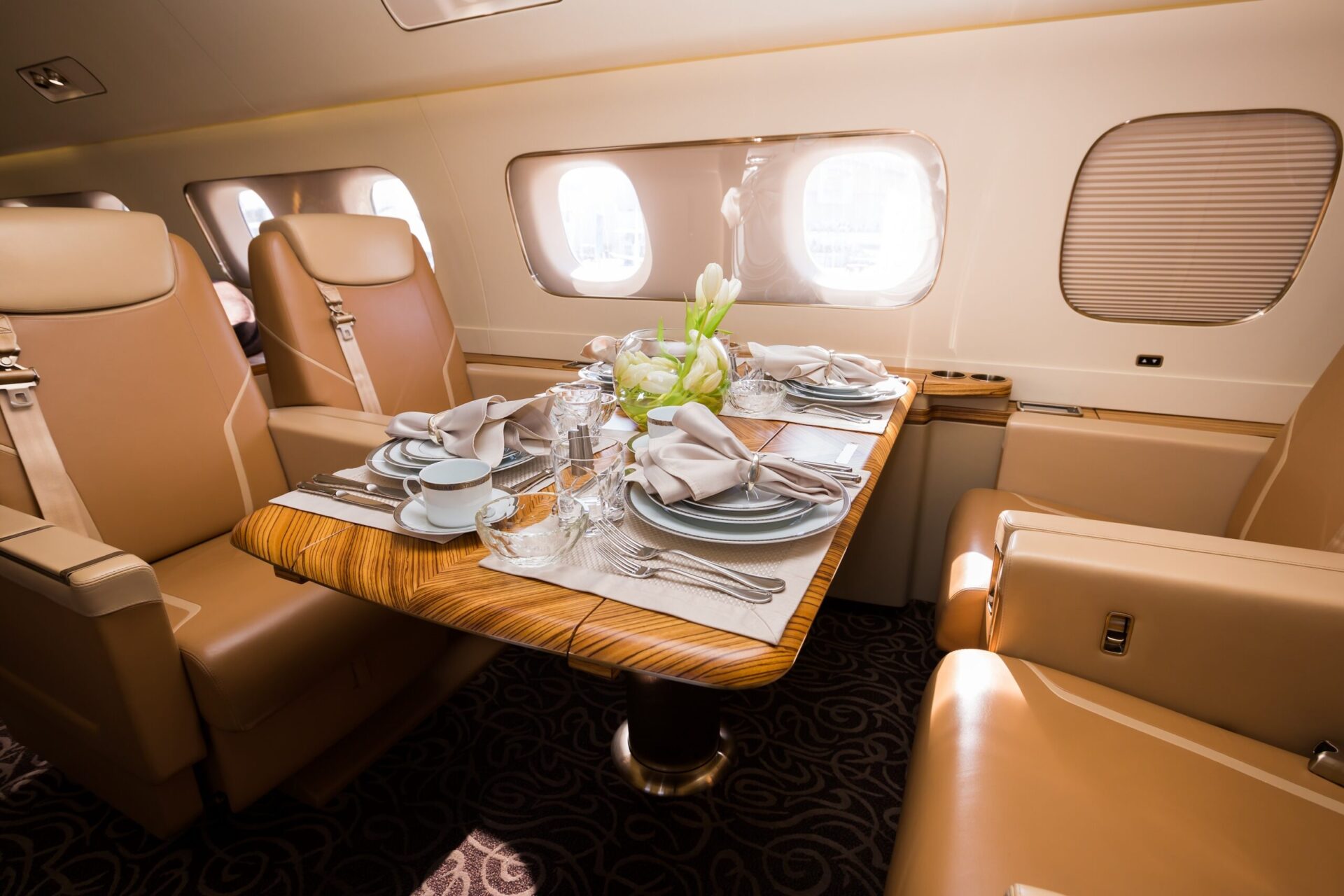 large private jet interior dining area with full table set with plates