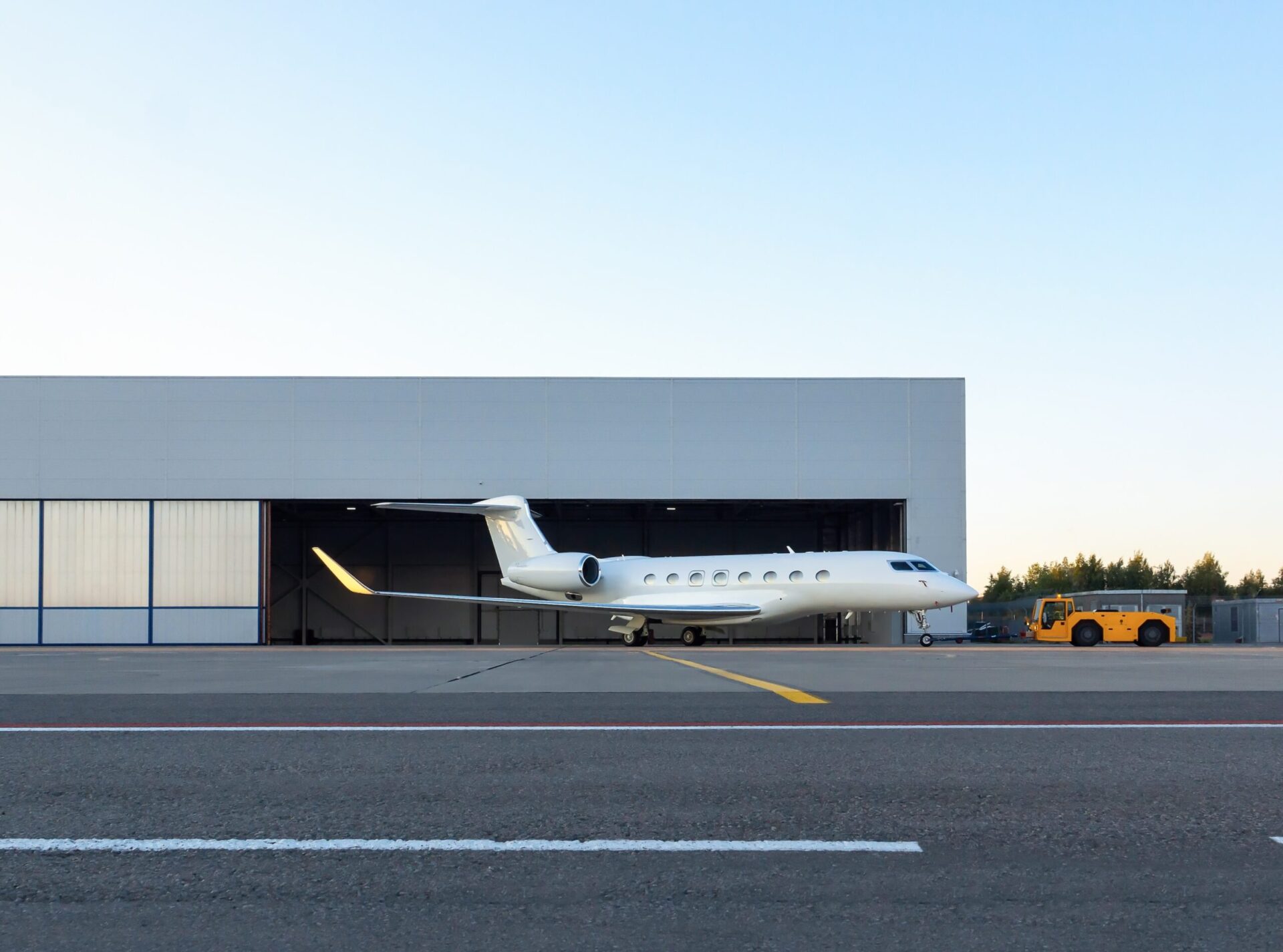 Gulfstream G650 being pushed by tug in front of hangar
