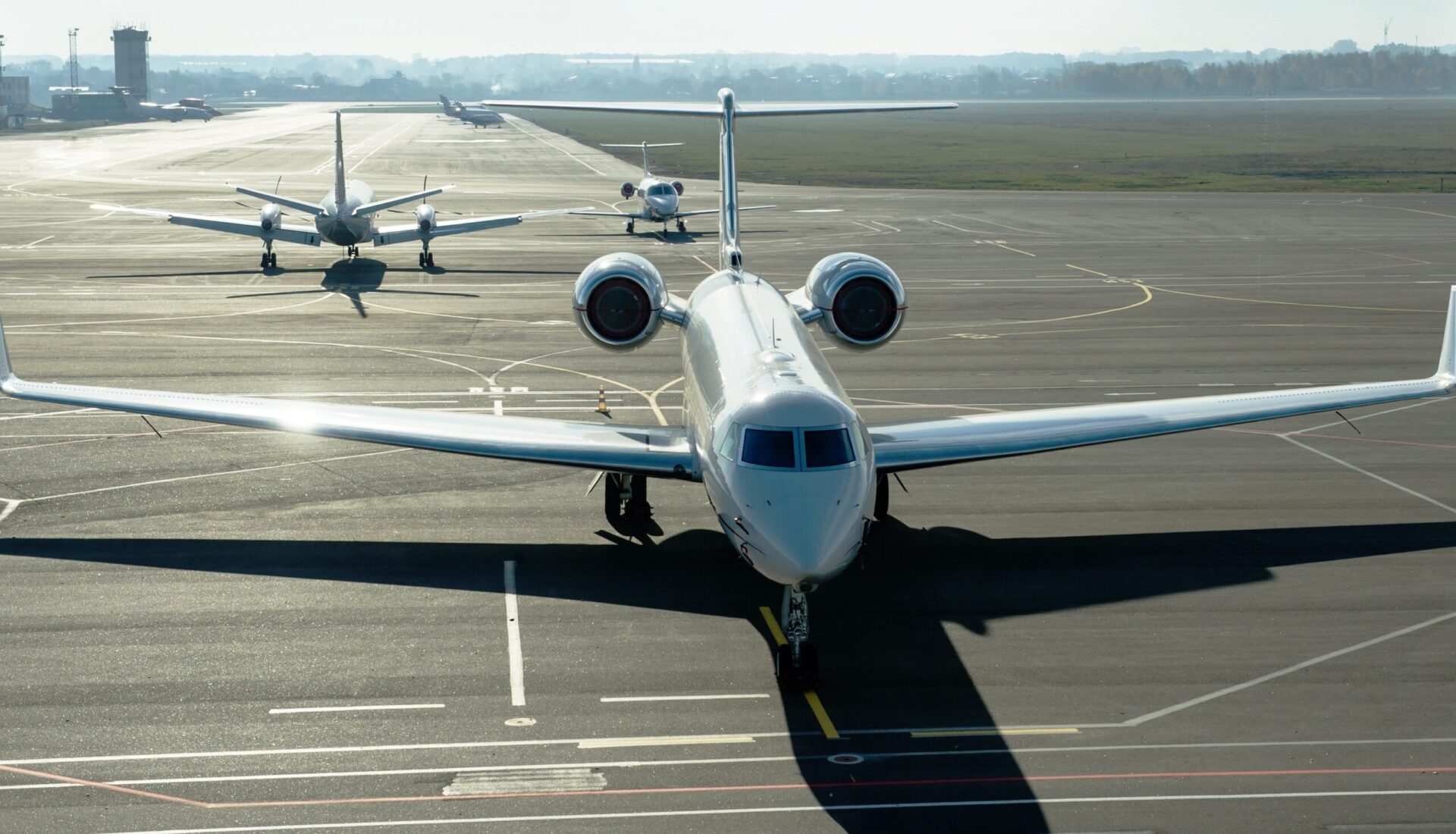 Front elevated view of private jet parked at airport with more in the background