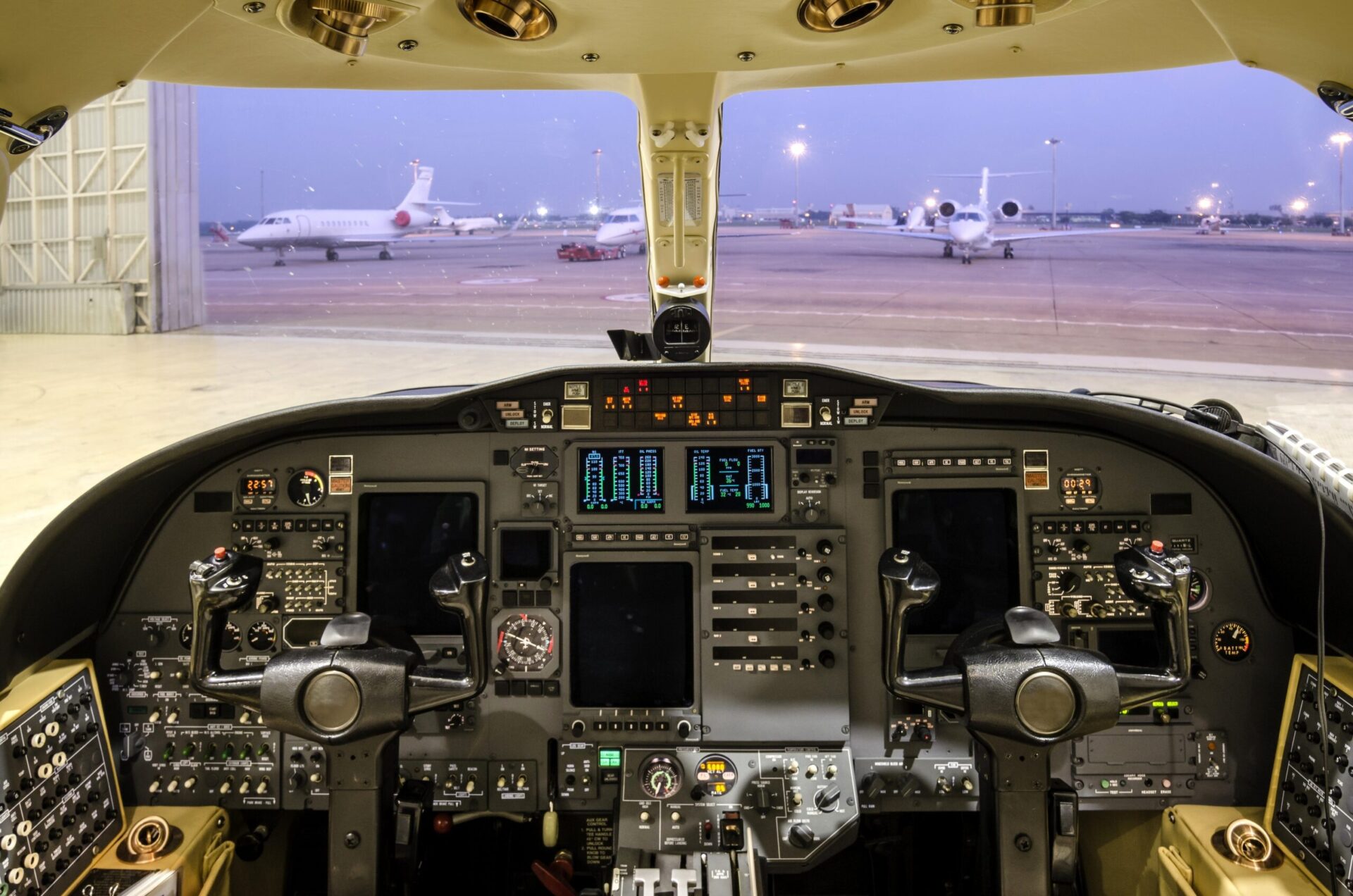 Citation cockpit view in hangar looking to apron