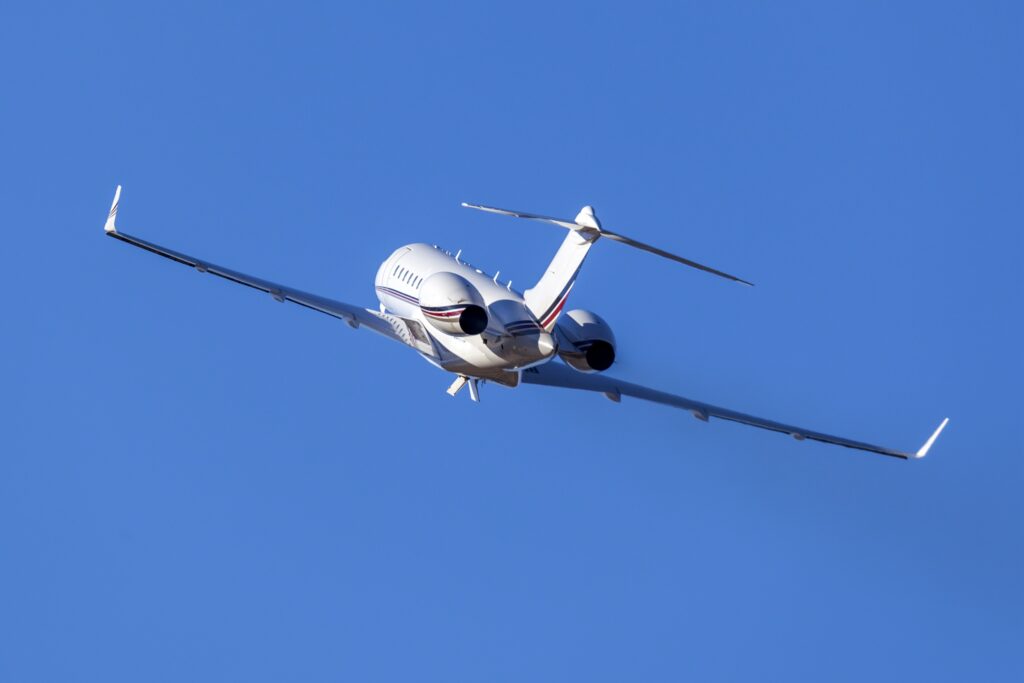 rear view of private jet taking off in the sky banking, going high in the sky