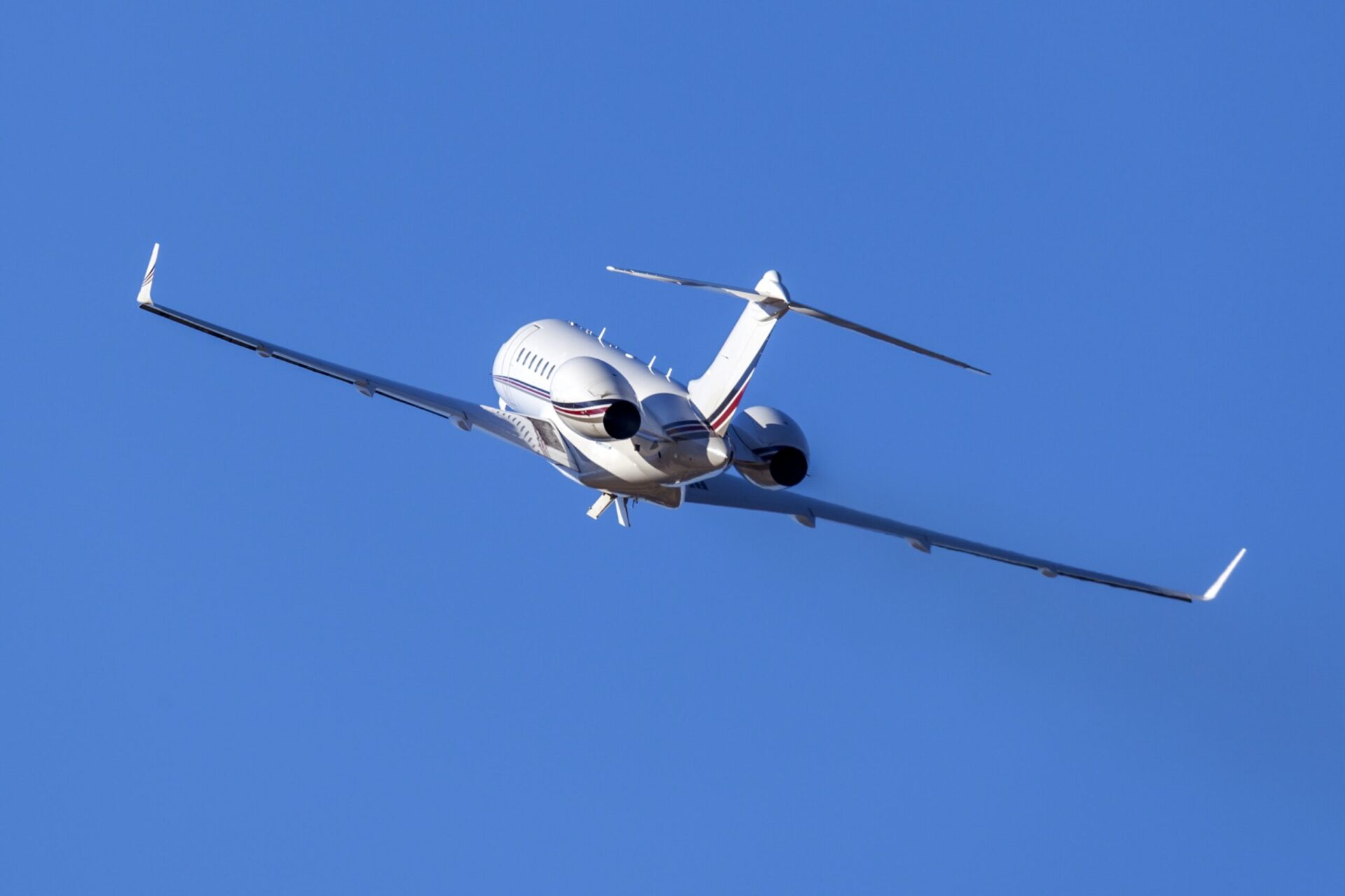rear view of private jet taking off in the sky banking