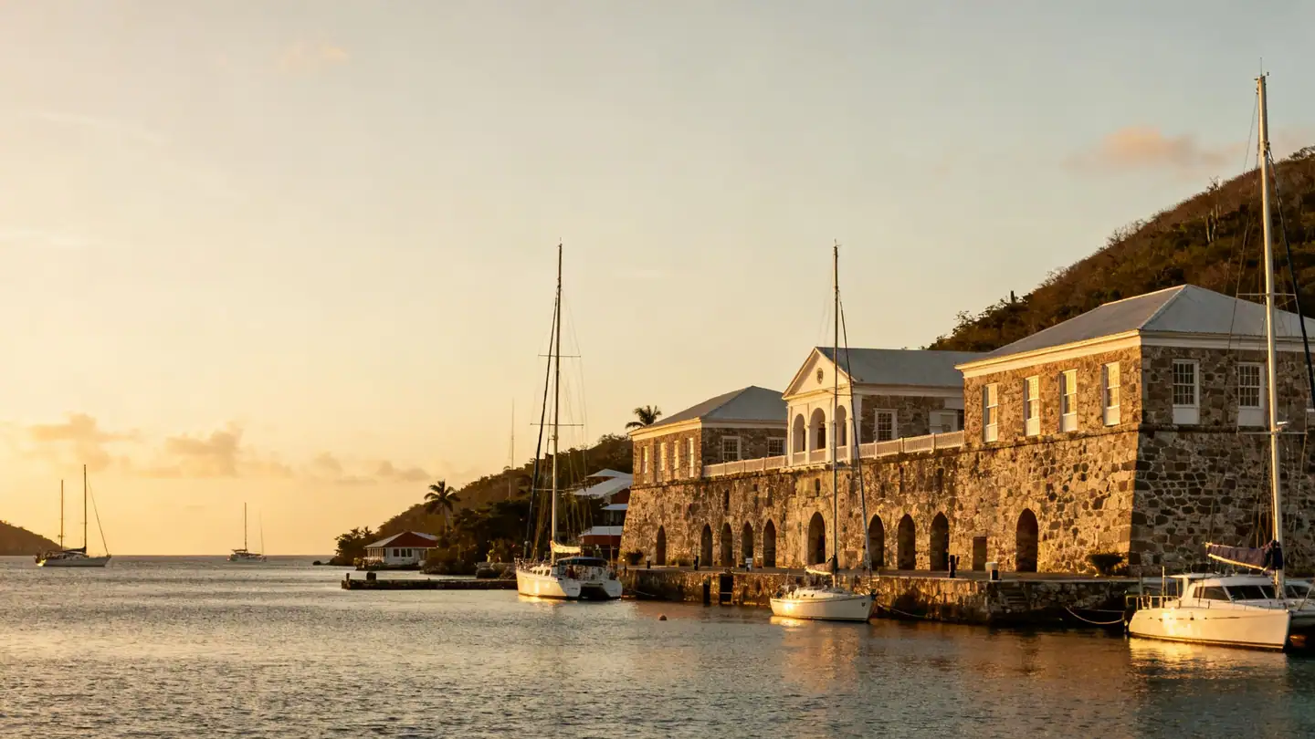 Antigua: a sheltered English Harbour with stone Georgian dockyard buildings and yachts in golden-hour light