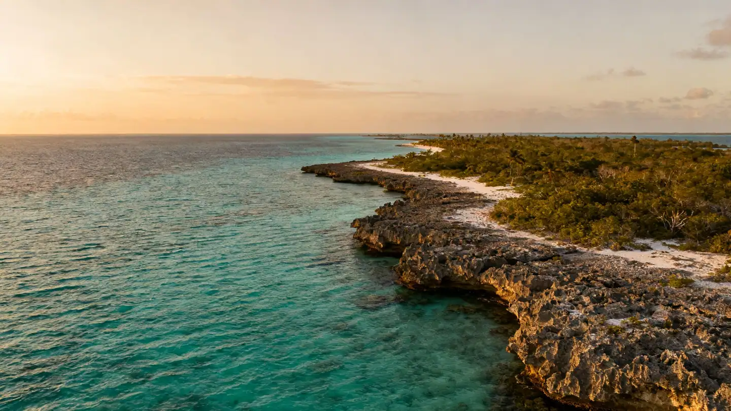 Belize: the barrier reef and clear turquoise cayes seen from low altitude in golden-hour light