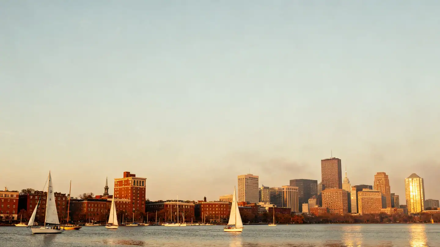 The Boston skyline across the Charles River in golden-hour light