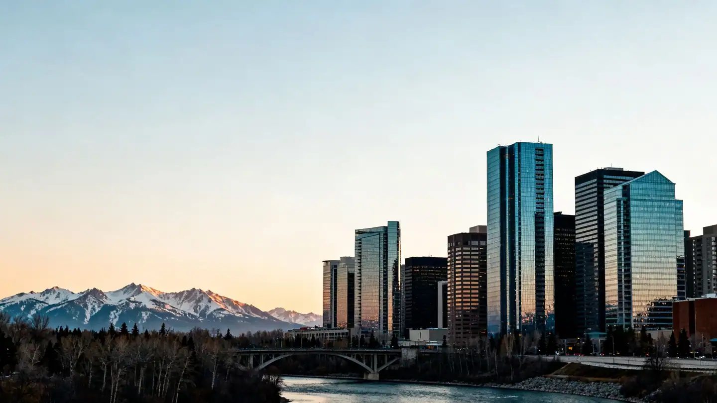 Calgary, Alberta: a skyline of glass office towers along the Bow River with the Rocky Mountains on the western horizon. No observation towers at sunset