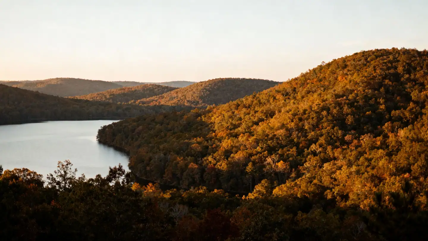The North Carolina Piedmont near Greensboro: rolling wooded hills and a lake in golden-hour light